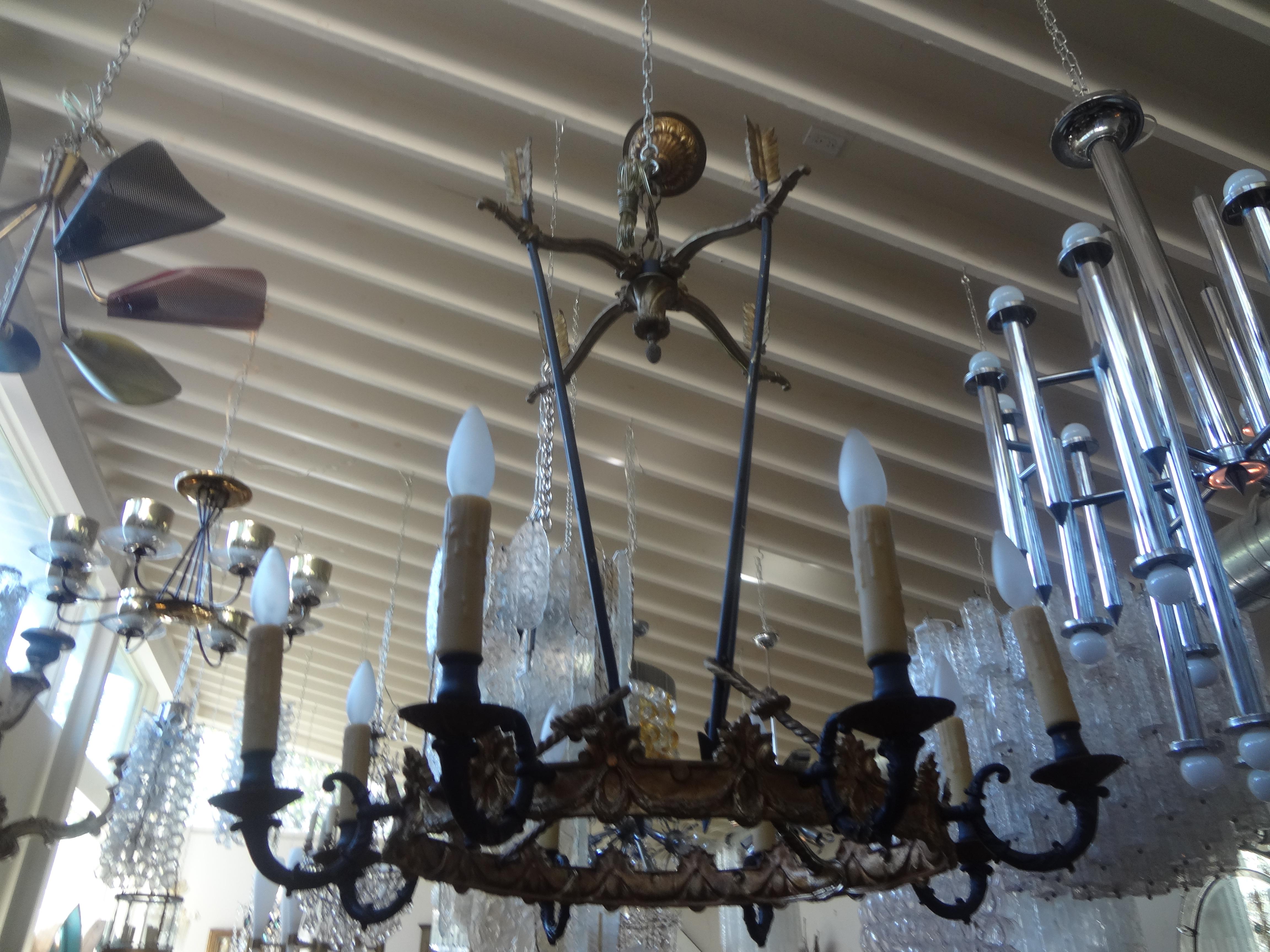 French Empire Style Bronze Chandelier With Arrows.
This stunning French Empire style or Directoire style gilt bronze and patinated bronze quiver and arrow chandelier features eight lights and has been newly wired to U.S. specifications. Each arm has