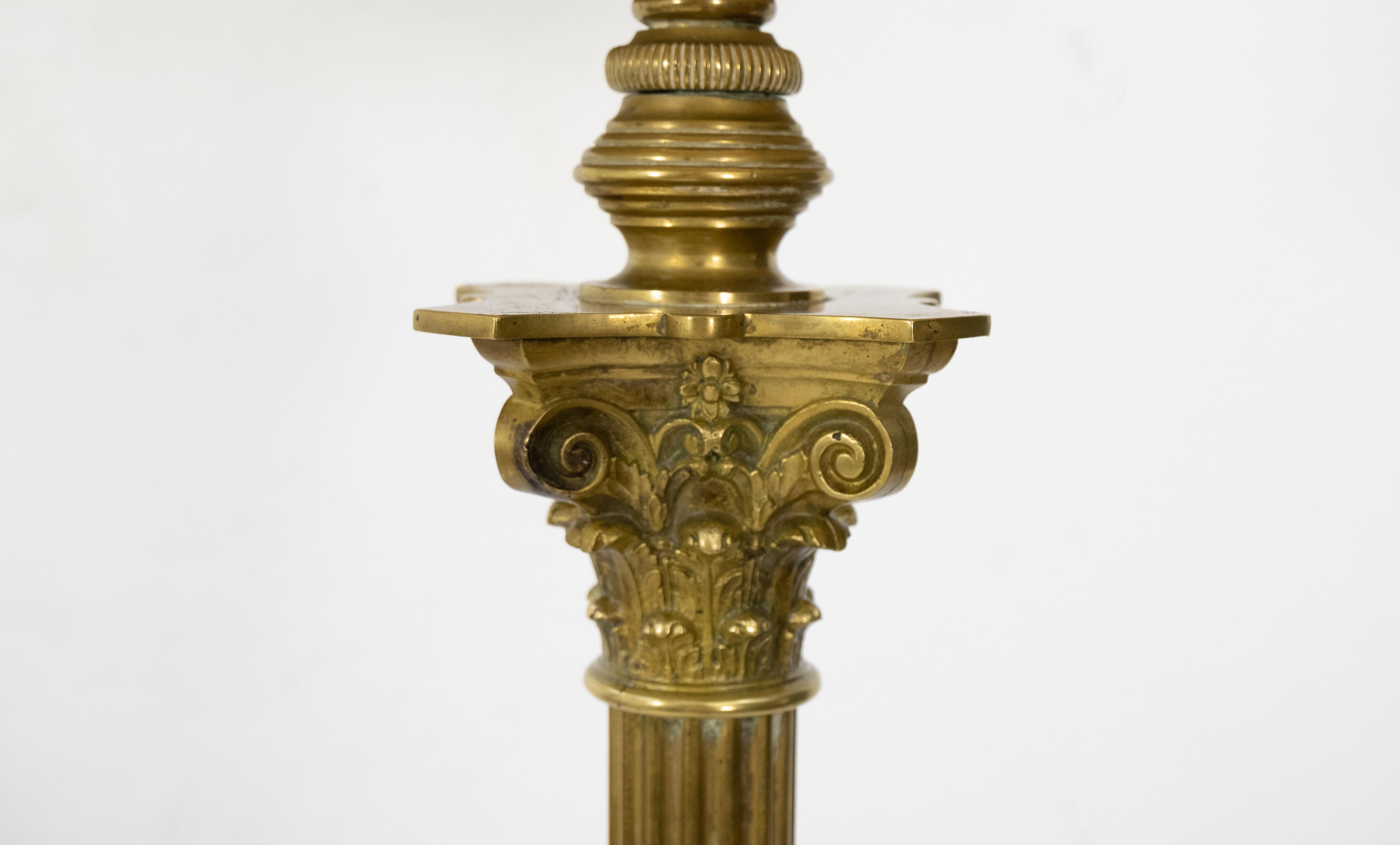 Antique French Empire style patinated bronze and ormolu column floor lamp topped by a solid bronze Corinthian capital, the stepped base cast with wreaths set on large feet.

  