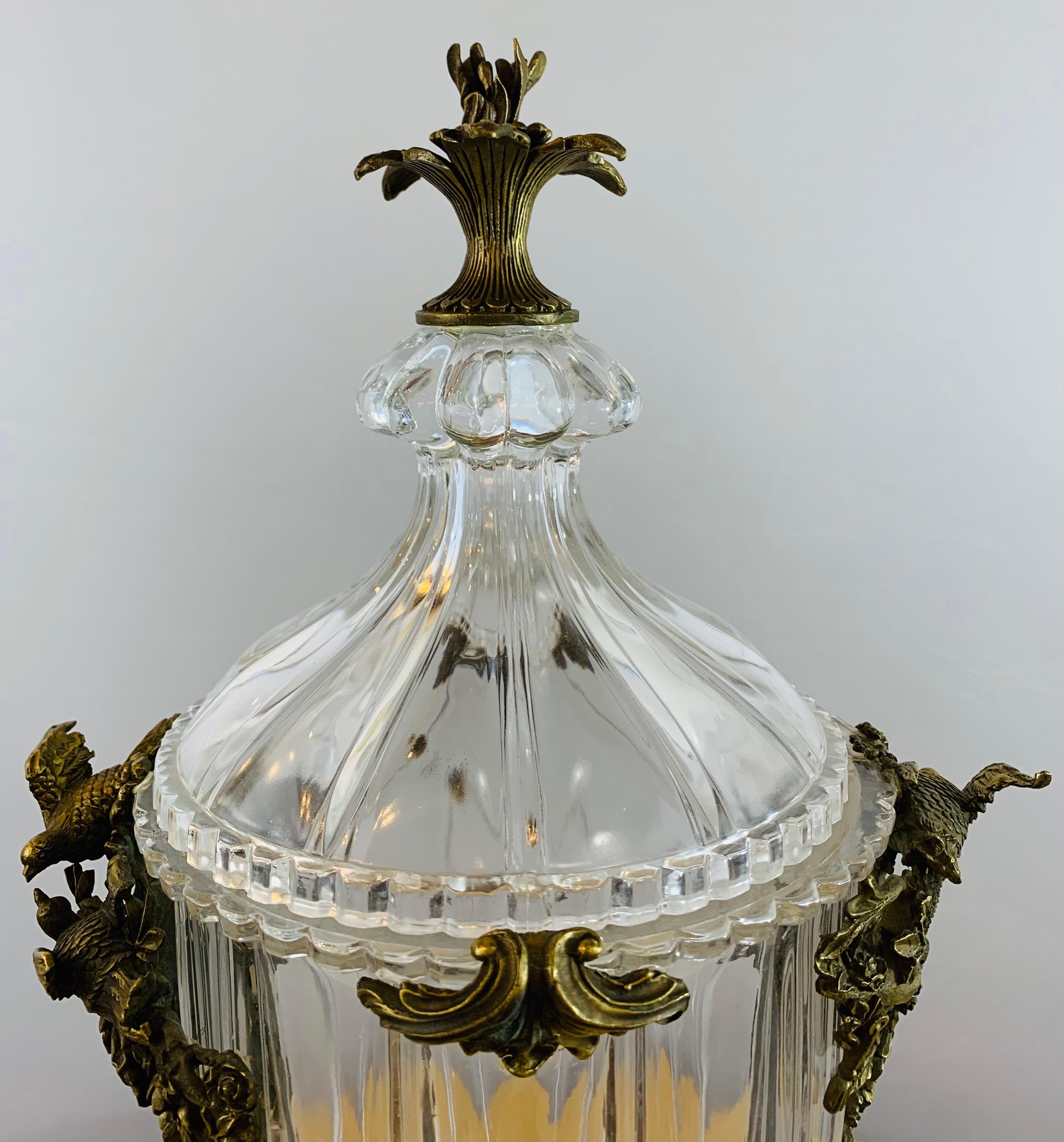 A classy French Empire style pair of bronze mounted cut crystal urn or vase featuring fine eagles and flowers bonze design on the sides and a blooming tulip shaped design on top of the lid 

Dimensions: 10