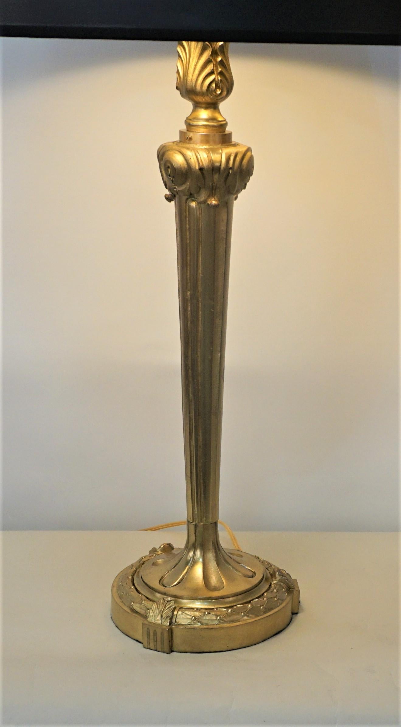An elegant bronze table lamp with adjustable height double pull chain lights and fitted with black gold liner shade.