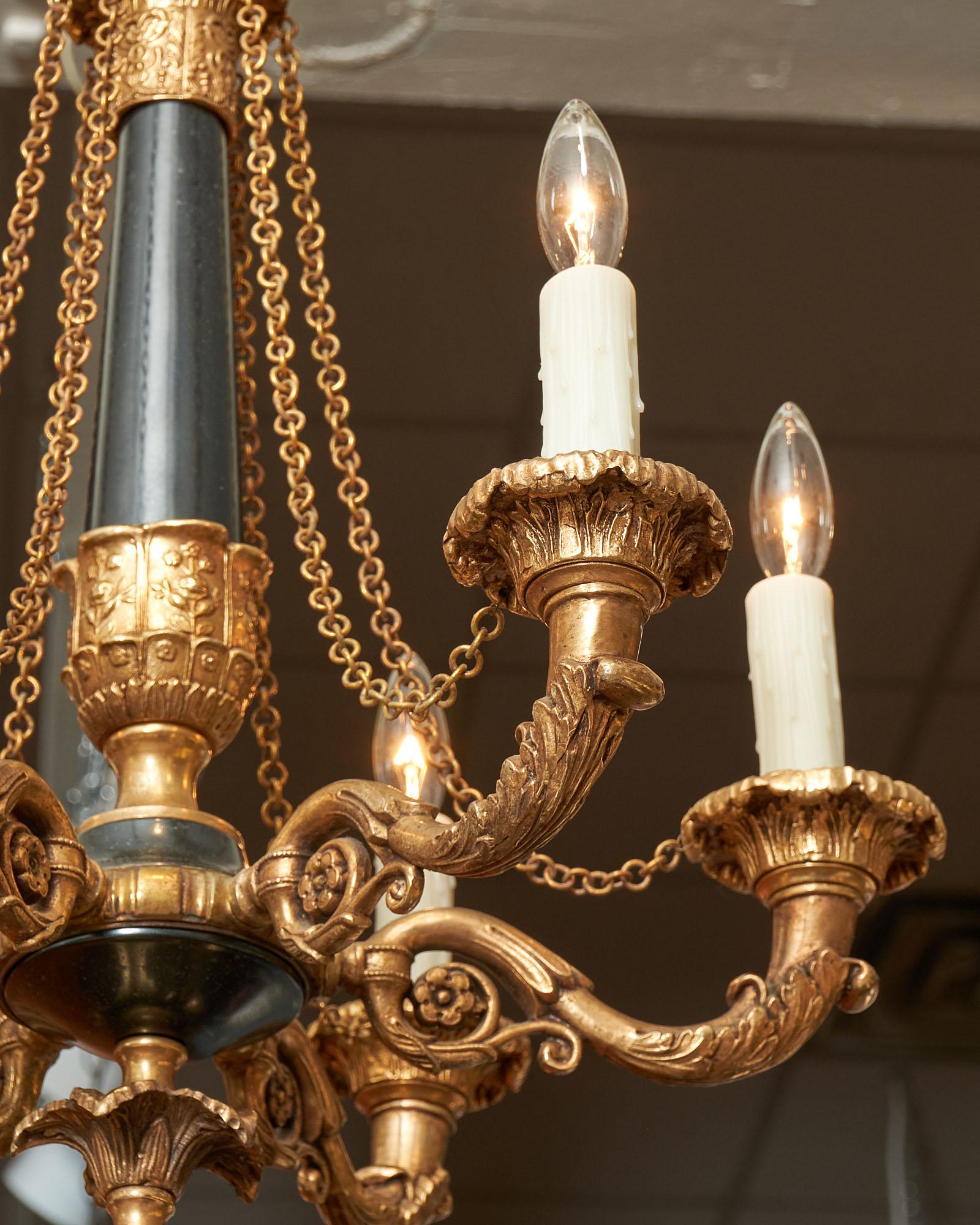 Chandelier in the French Empire style featuring finely cast bronze elements and six branches with chains. It has been newly wired to fit US standards.