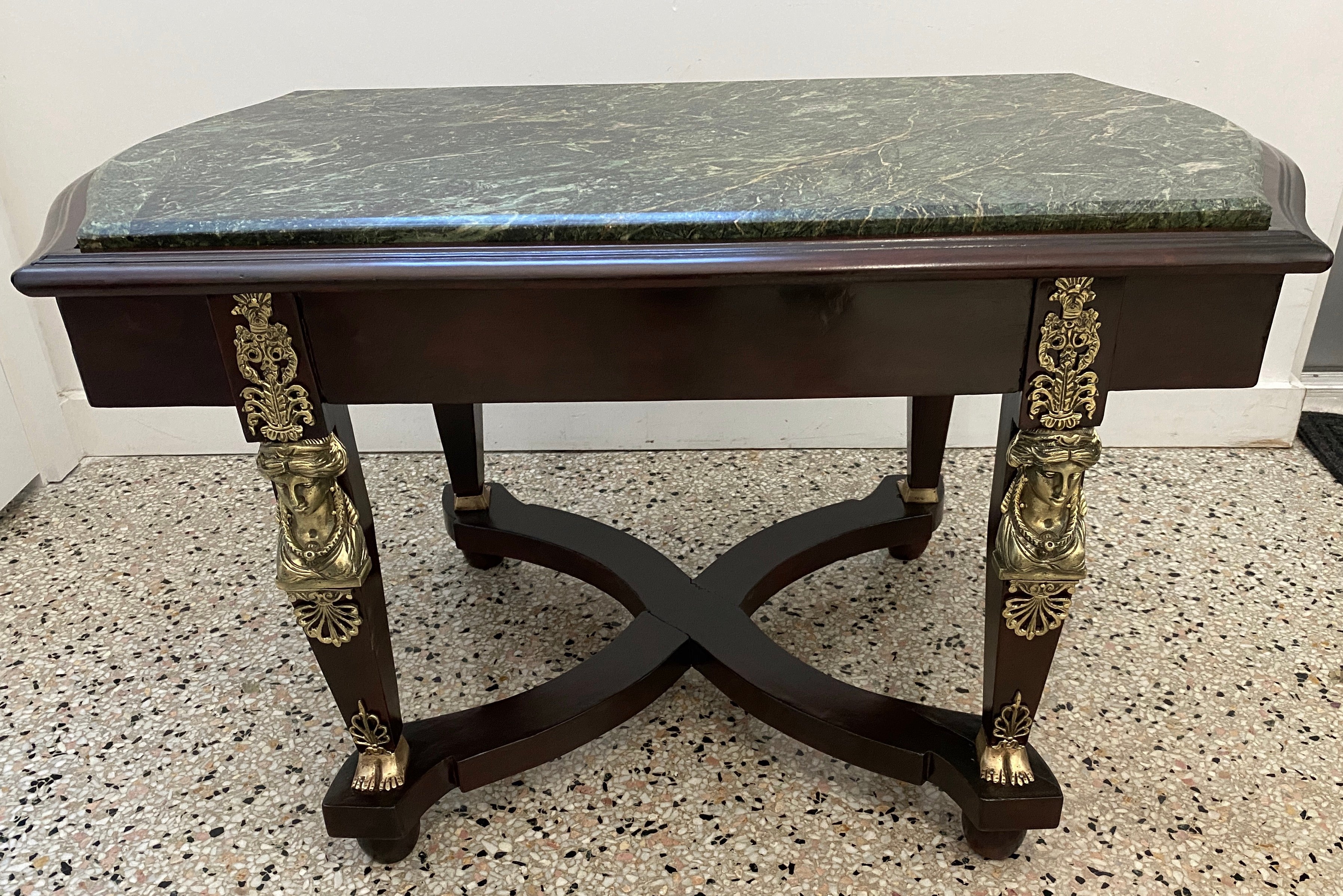 This stylish cocktail table dates to the 1920s-1930s and is in the French Empire Revival form.