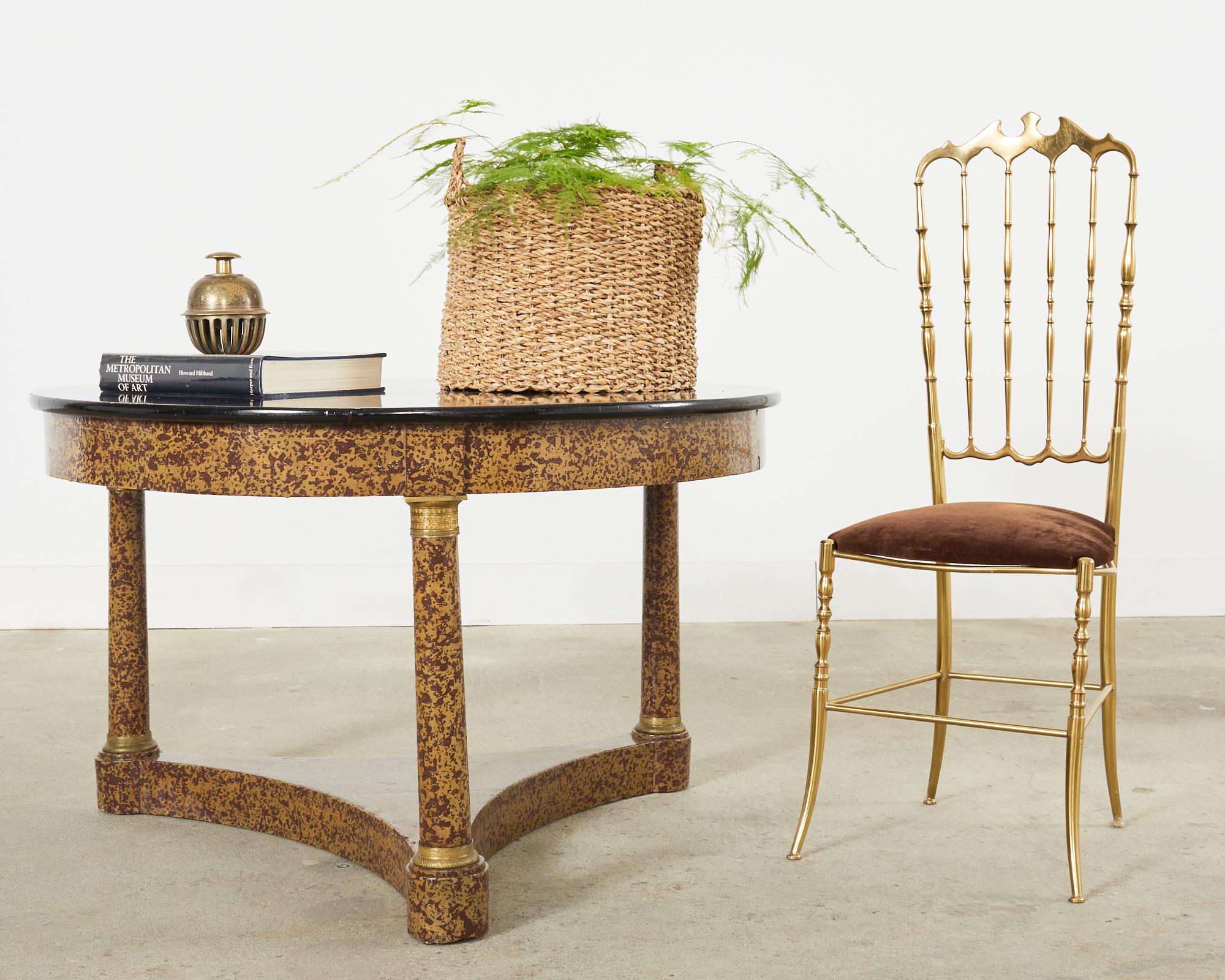 Whimsical round coffee or cocktail table lacquer speckled by artist Ira Yeager (American 1938-2022). The table is made in the French Napoleonic empire style featuring bronze mounted round legs. The stunning finish has a beige ground with brown