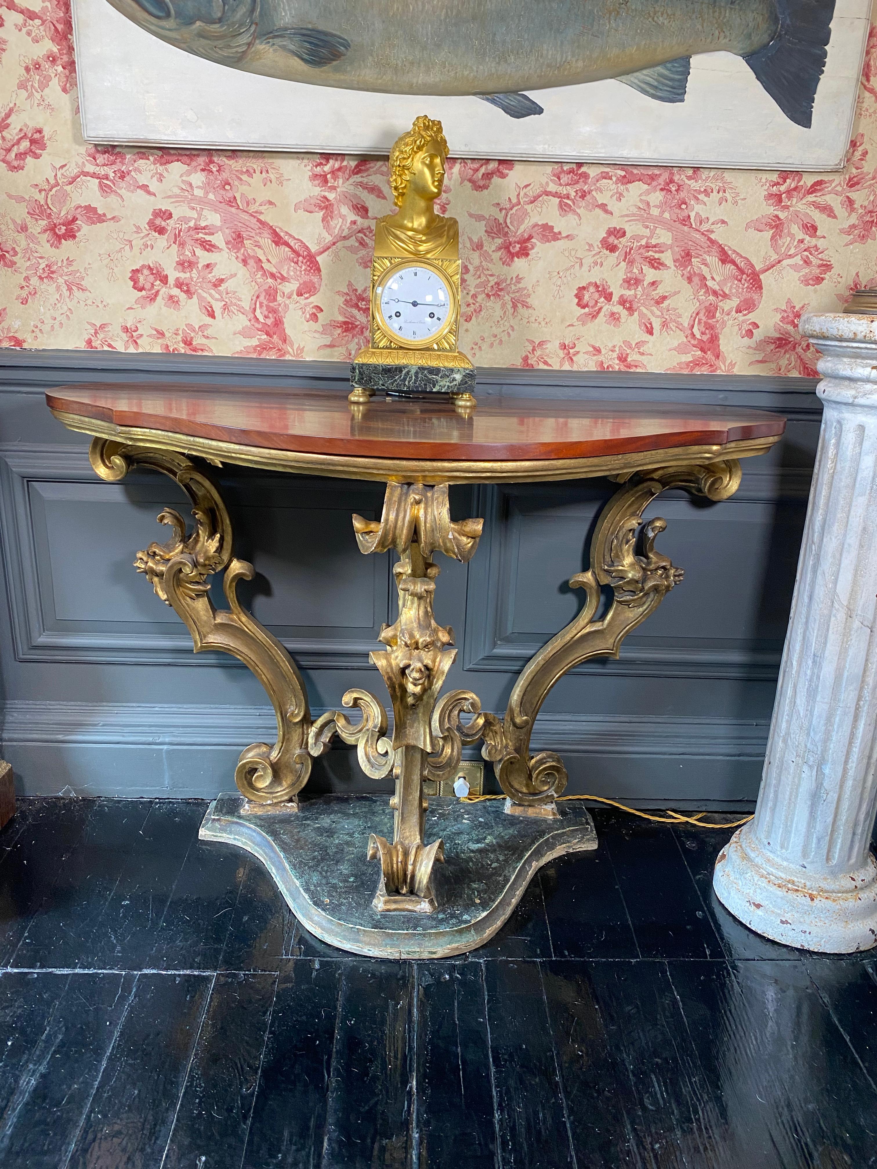 A wonderful french empire style console table on gilded gesso legs with a faux green marble painted base and mahogany top.