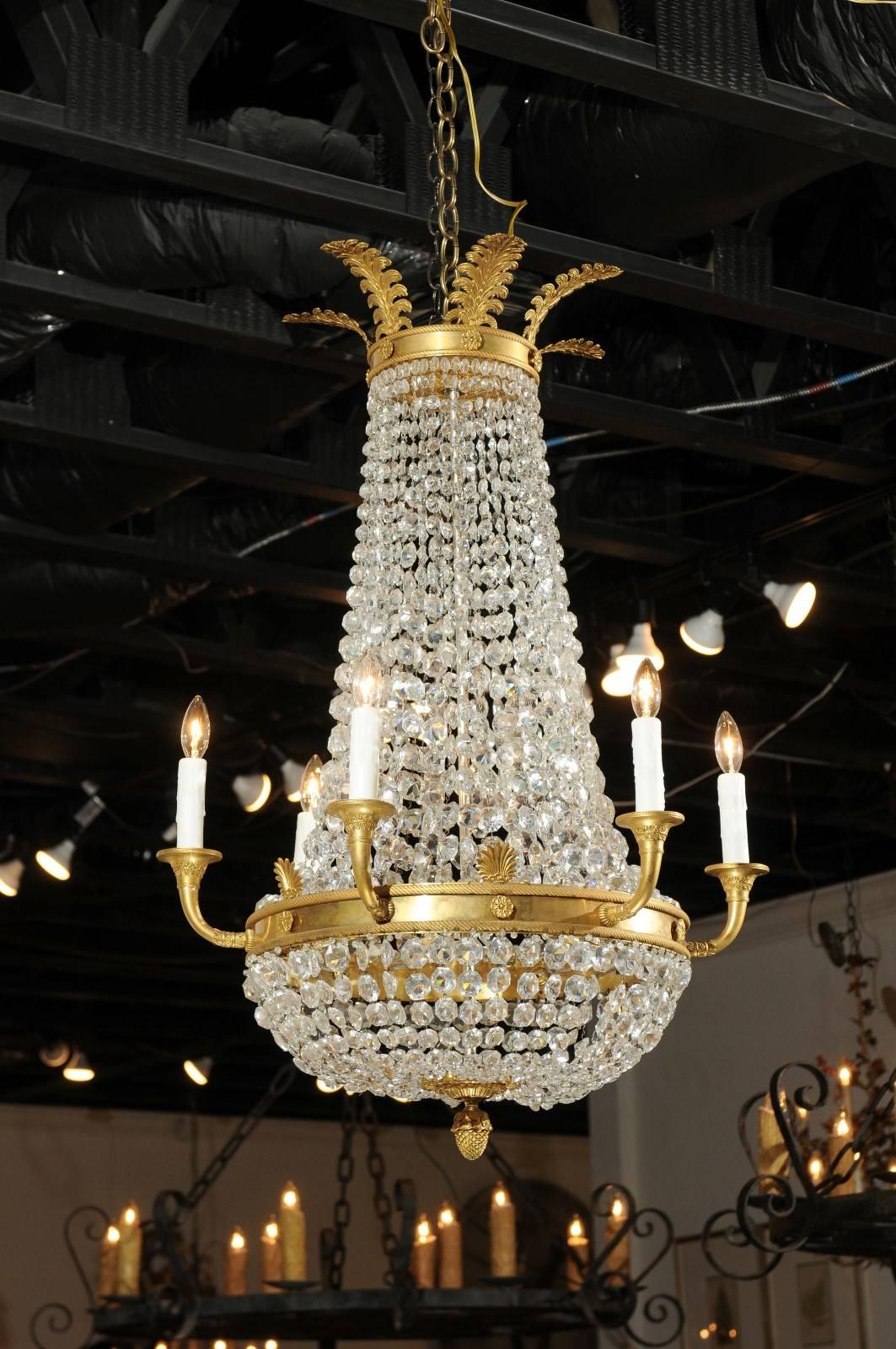 A French Empire style crystal and gilt metal waterfall basket six-light chandelier from the late 19th century. This exquisite French basket chandelier features a tall silhouette, accented by a gilt metal frame. Ornate acanthus leaves decorate the