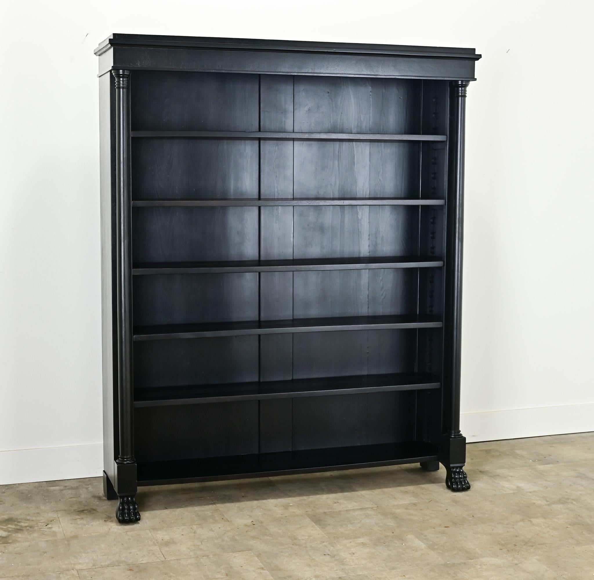 This handsome Empire style open book shelf has a recent ebonized finish. This antique has the rounded column fronts of the empire style raised on paw feet. The interior is fitted with five adjustable shelves, 10” deep. Cleaned and tightened this