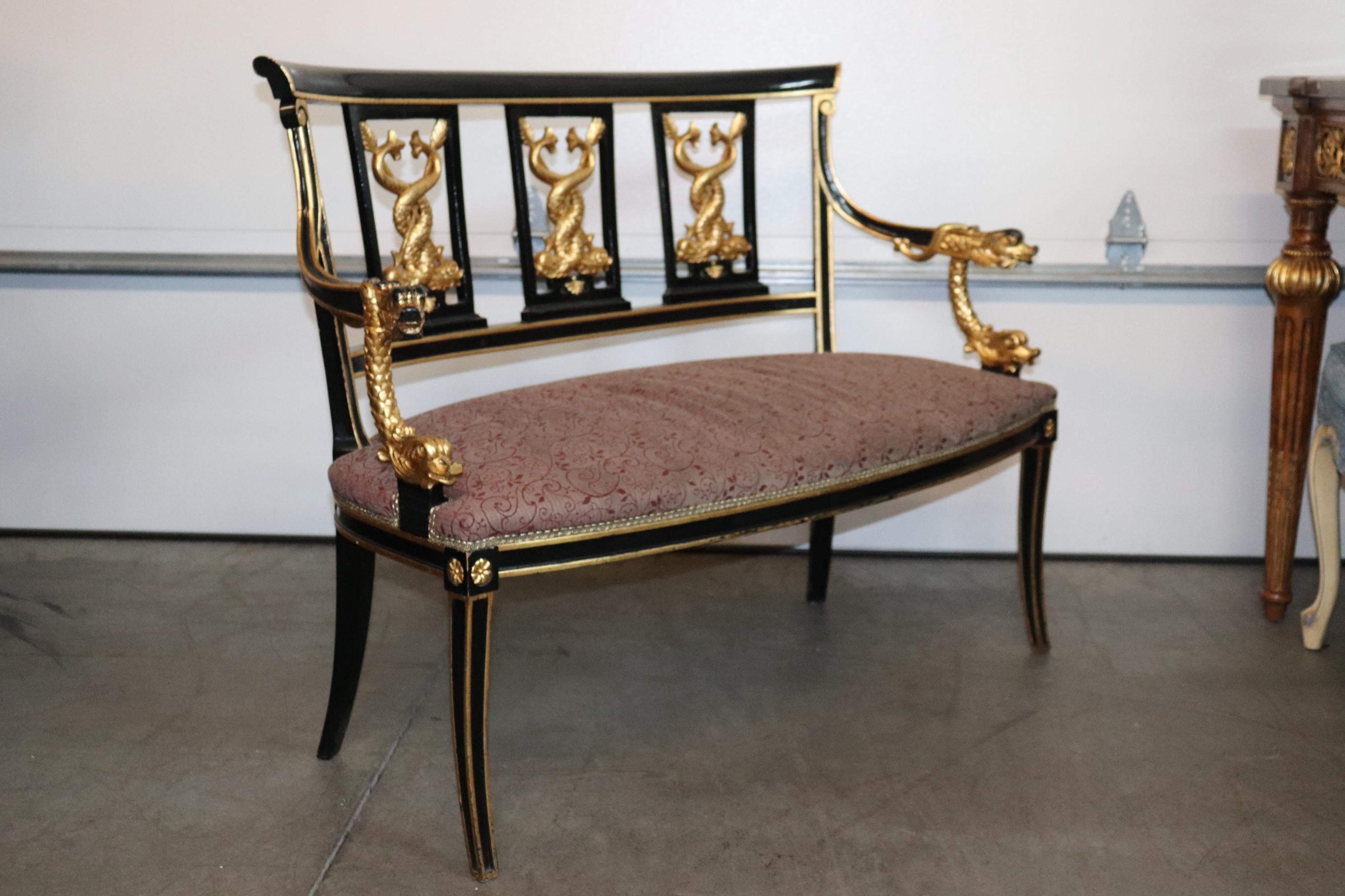 This is an outrageously beautiful French Empire settee. The settee is done in black lacquer and the carving is done in genuine gold leaf and absolutely luminous and bright. This is a statement piece, a true focal point for the middle of a roon. The