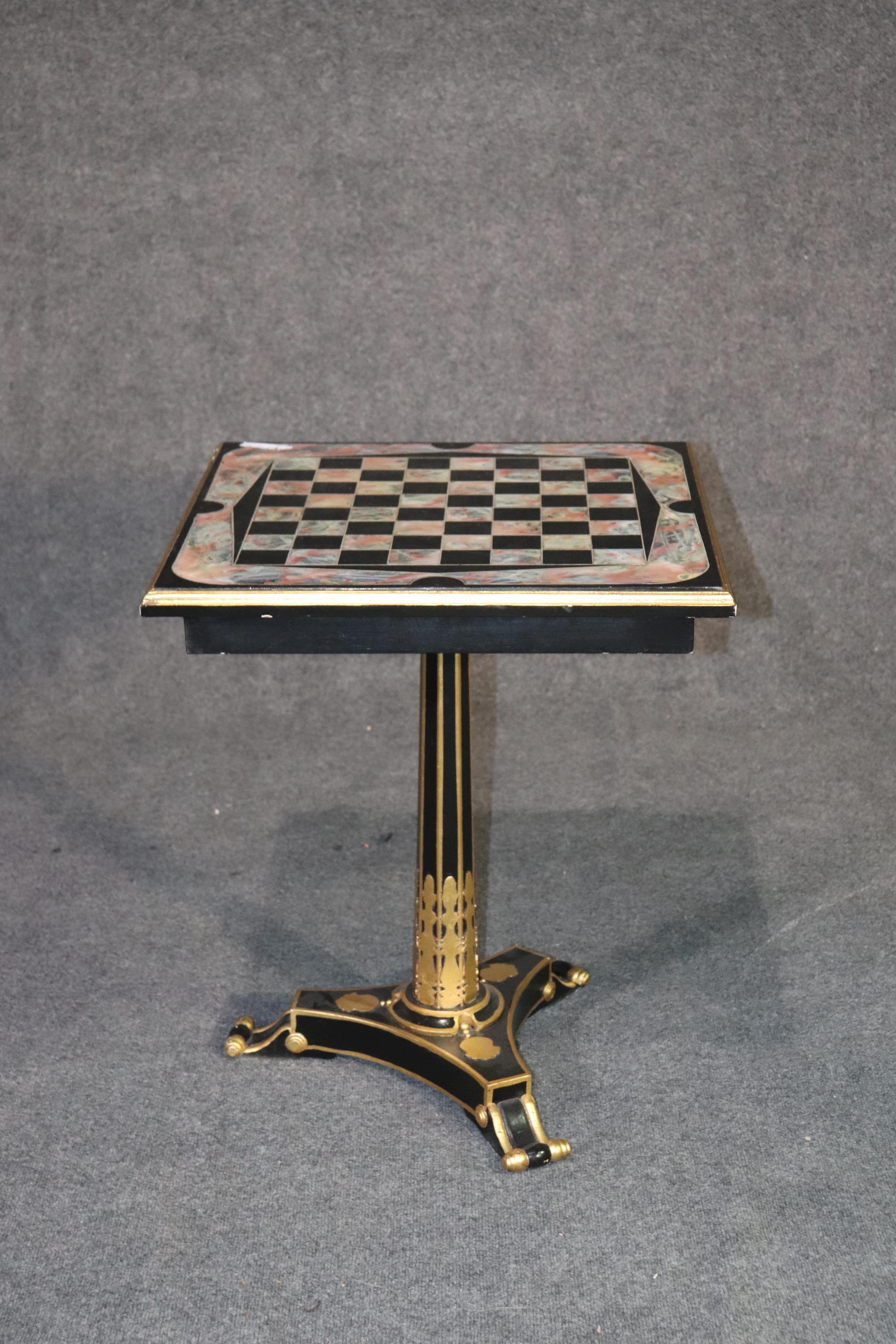 This is a beautifully designed French Empire style games table. Perfect for chess or checkers, this tables features an ebonized frame with faux marble decorated top and gilded elements to add even more luxury to this table. The table measures 27 3/4