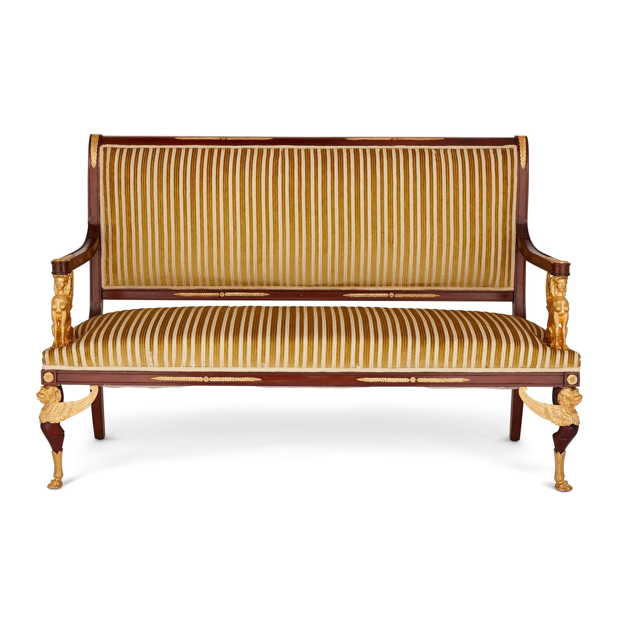 French Empire style gilt-bronze and mahogany five-piece salon suite
French, Late 19th Century 
Sofa: Height 107cm, width 162cm, depth 65cm
Armchair: Height 101cm, width 68cm, depth 63cm 
Chair: Height 96cm, width 55cm, depth 57cm

This superb