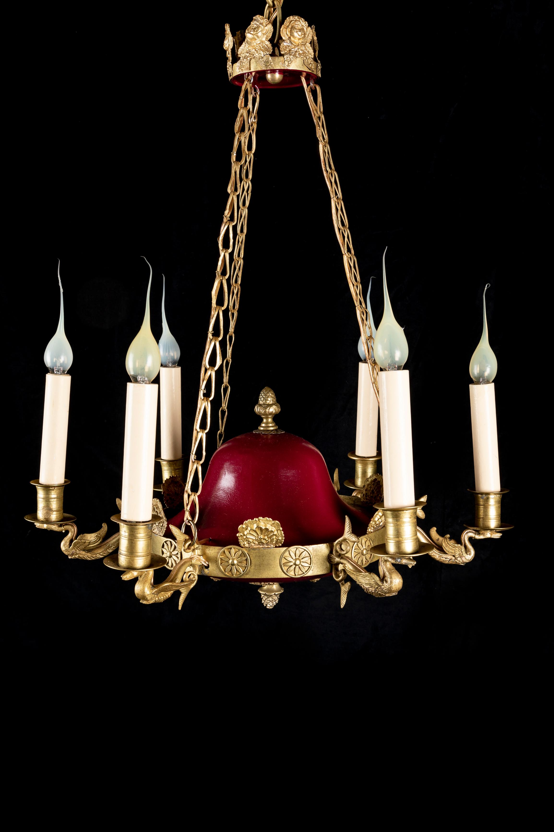 A FIne French Empire Style GIlt Bronze and red painted tole six light swan chandelier embellished with neoclassical gilt bronze motifs in relief, six gilt bronze swans. This unusual chandelier is further adorned with gilt bronze chains and a