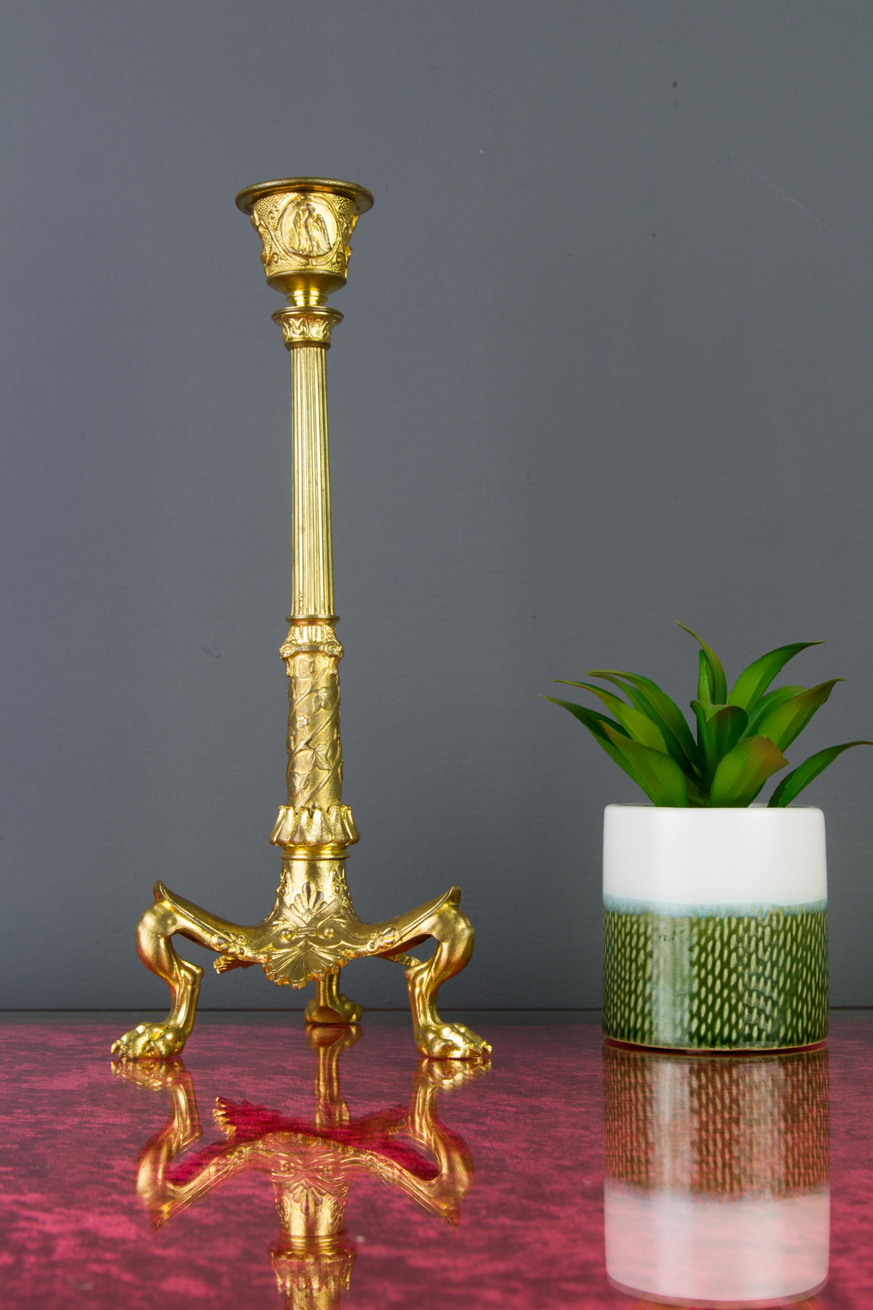 Fine French Empire style gilt bronze candleholder from the Napoleon III period. A fluted column beautifully decorated with Ivy rises on a tripod with claw-shaped paw feet. This antique candleholder features typical Empire style décors with spears