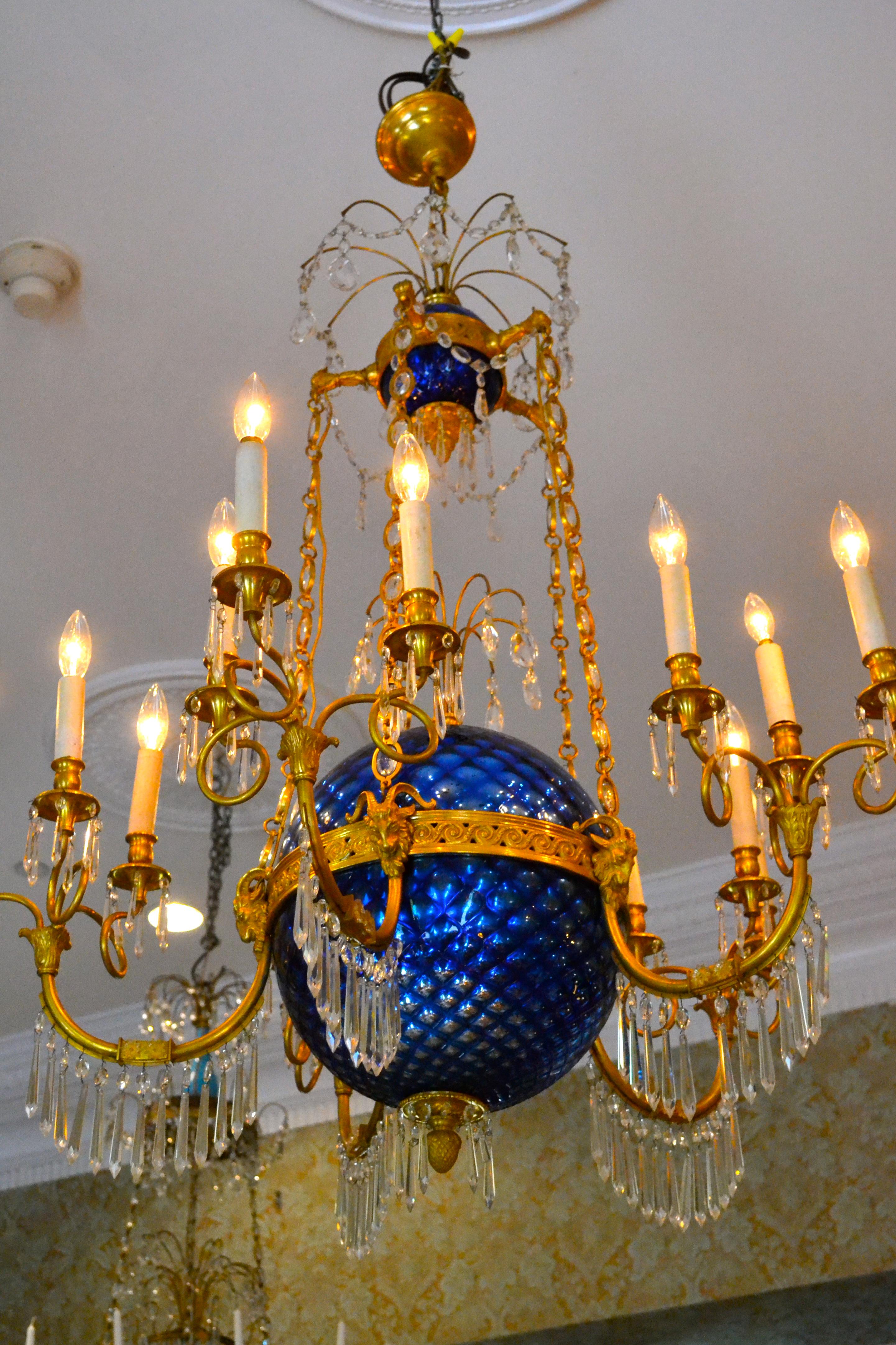 A Russian influenced  crystal and gilt bronze chandelier styled from the early 19th century Empire period, this chandelier likely dating from the early 20th century. Five bronze and crystal chains support a large round blue mercury glass bowl, from