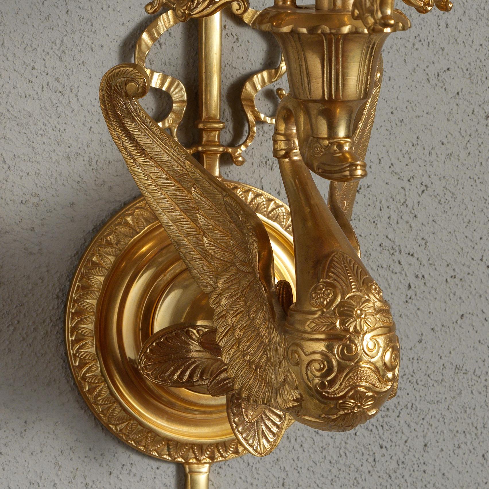 Dieser Wandleuchter im französischen Empire-Stil aus vergoldeter Bronze von Gherardo Degli Albizzi zeichnet sich durch handziselierte Details von höchster Qualität aus.
Die Rückwand dieser Leuchte besteht aus einer runden Platte in der Mitte und