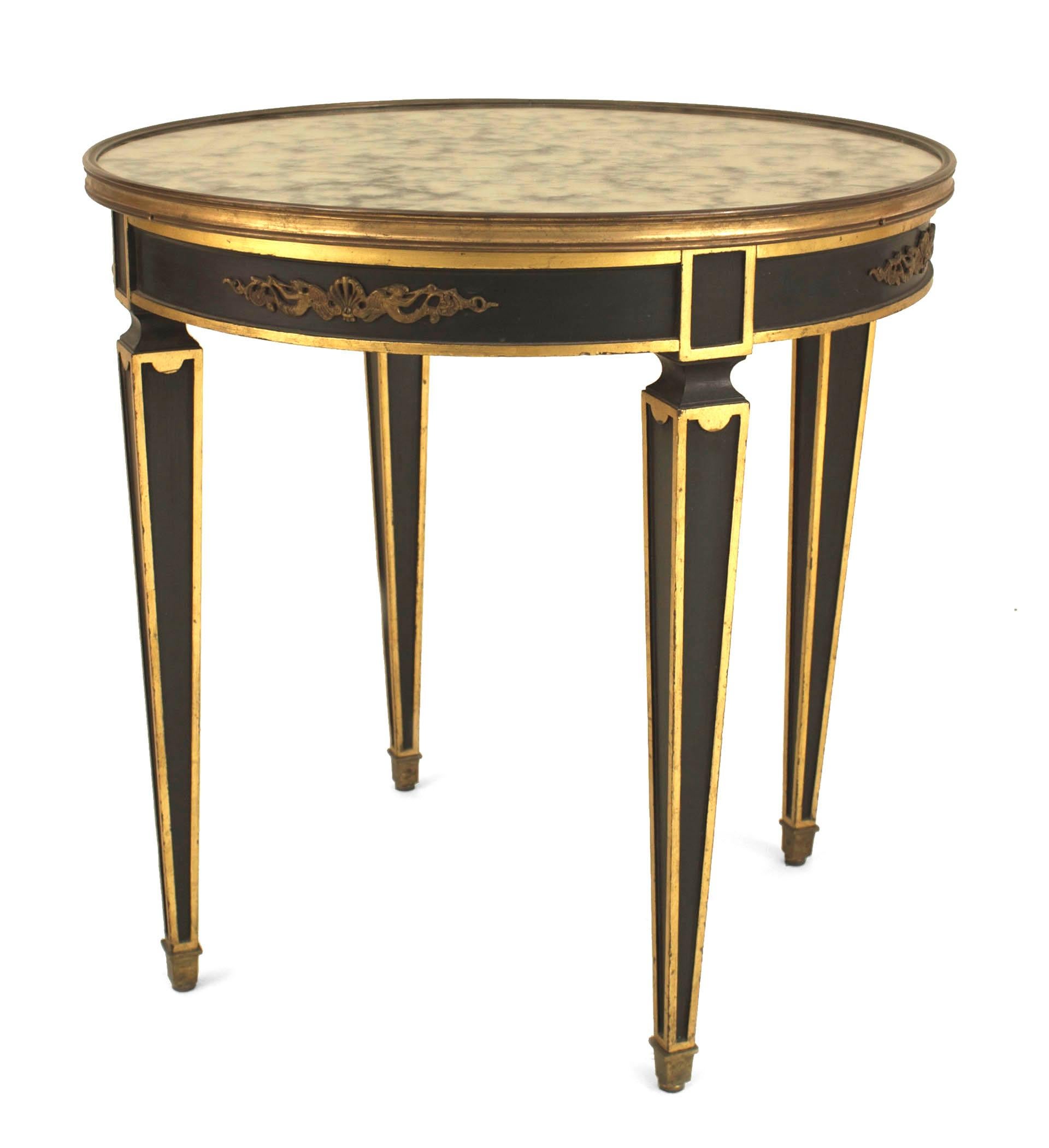 French Empire-Style (1940s) ebonized and gilt trim round end table with bronze trim on apron and a top rim surrounding a mottled mirrored round top. (Attributed to MAISON JANSEN)
