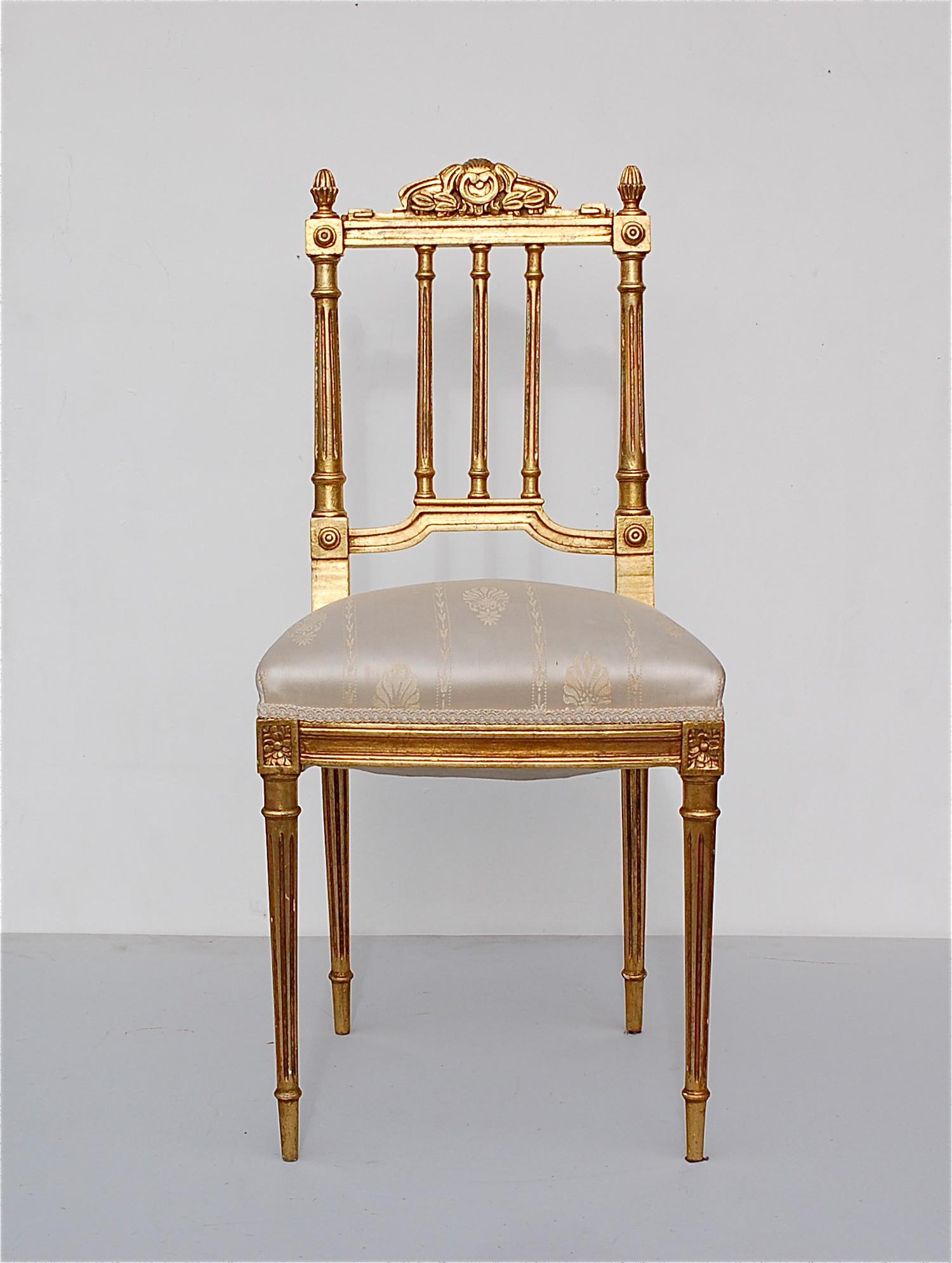 Giltwood accent, salon or boudoir chair designed in a French neoclassical, Louis XIV, Empire, Hollywood Regency style. It has a sprung seat that's upholstered in a cream white satin with a classic design motif. It's a solidly built chair, with a