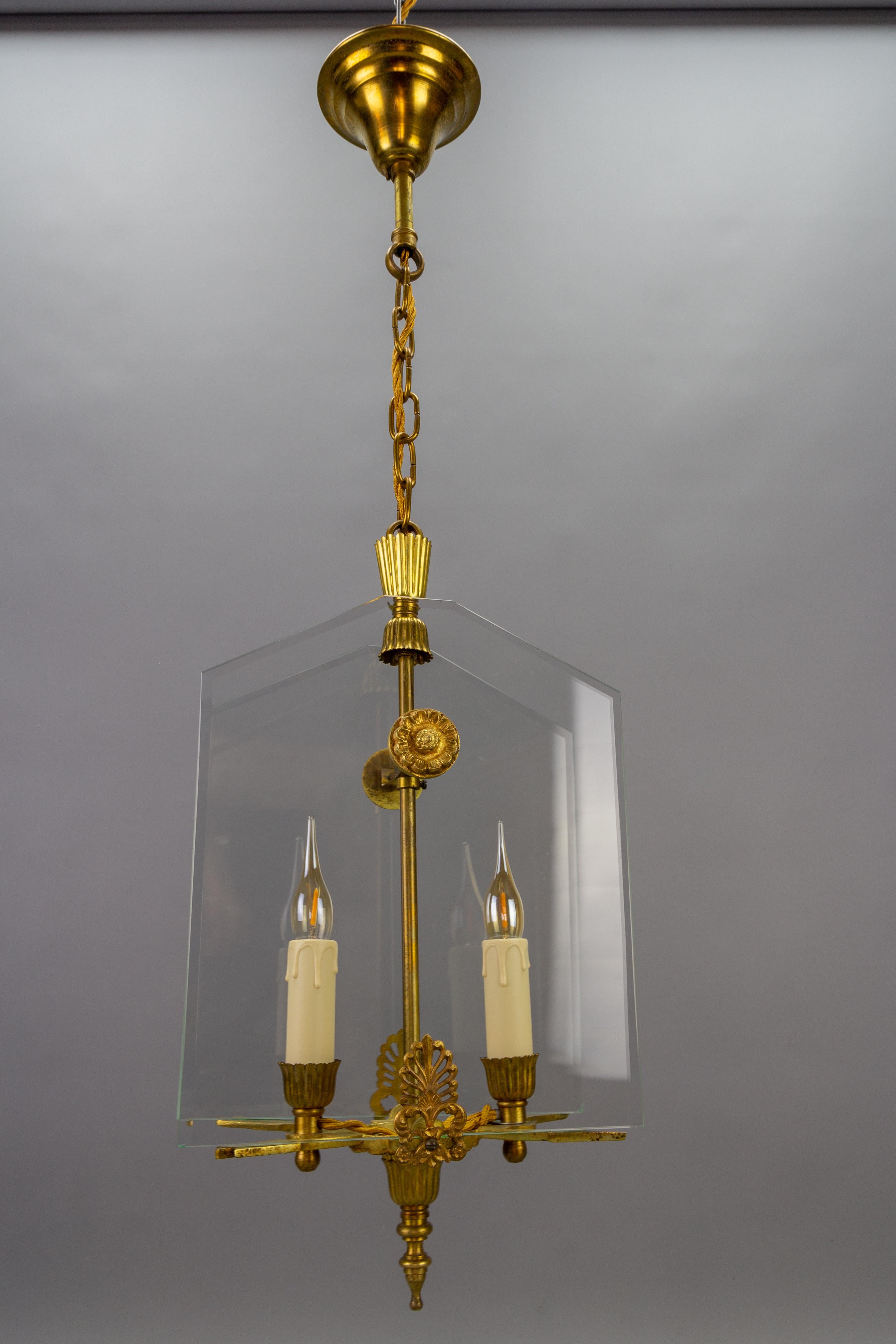 French Empire-style glass and bronze two-light Pendant Chandelier, circa the 1950s.
This absolutely adorable Empire-style chandelier features a bronze frame with two arrows and two beveled glass panels. 
Two sockets for E14 size light