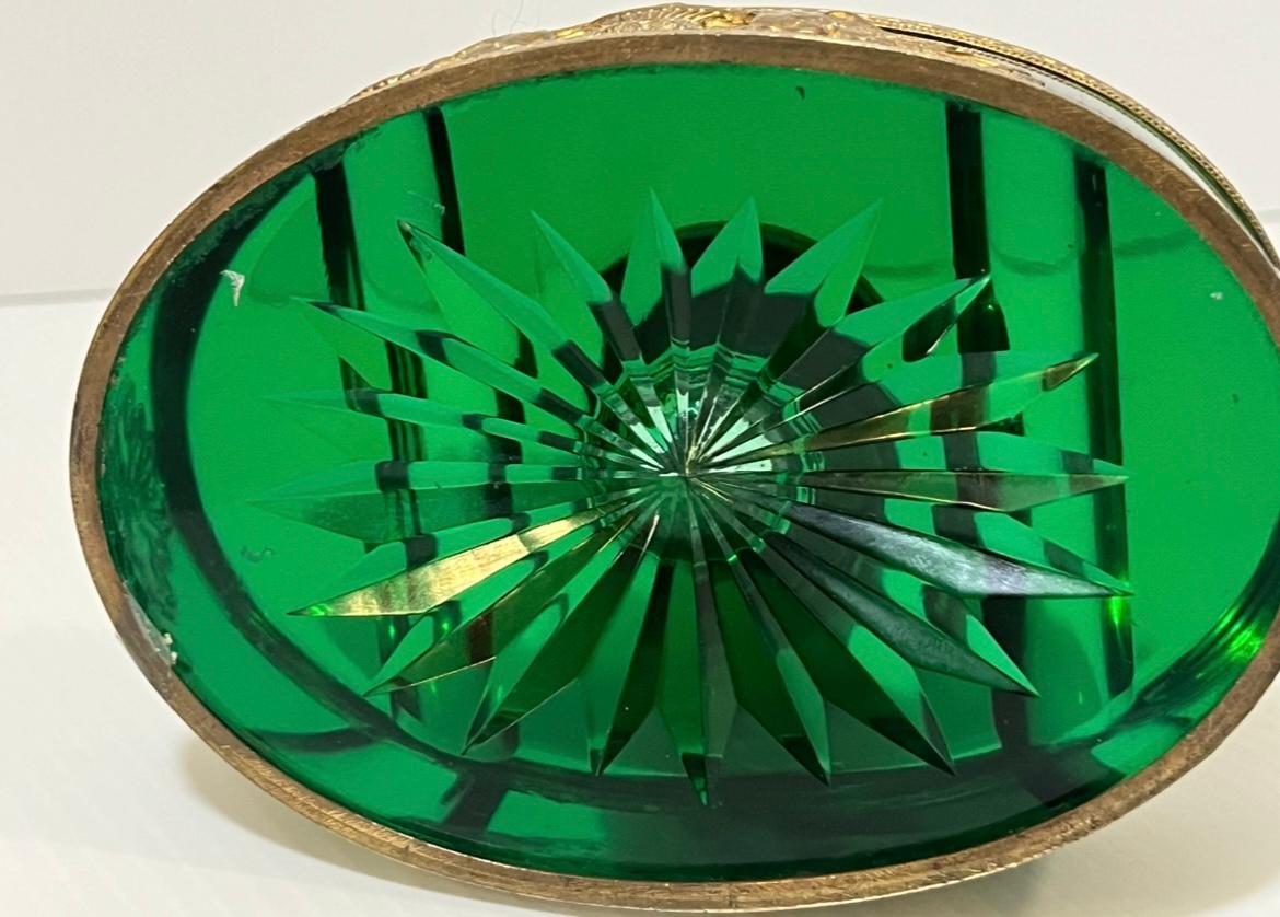 Second Empire green glass inkwell circa 1870 .rare color .Encased in gilt metal Empire styled mounts ,swans drinking from a fountain. The lid shows a woman with bust . The ovoid green glass with sunburst base and pen holding grooves on top . Very