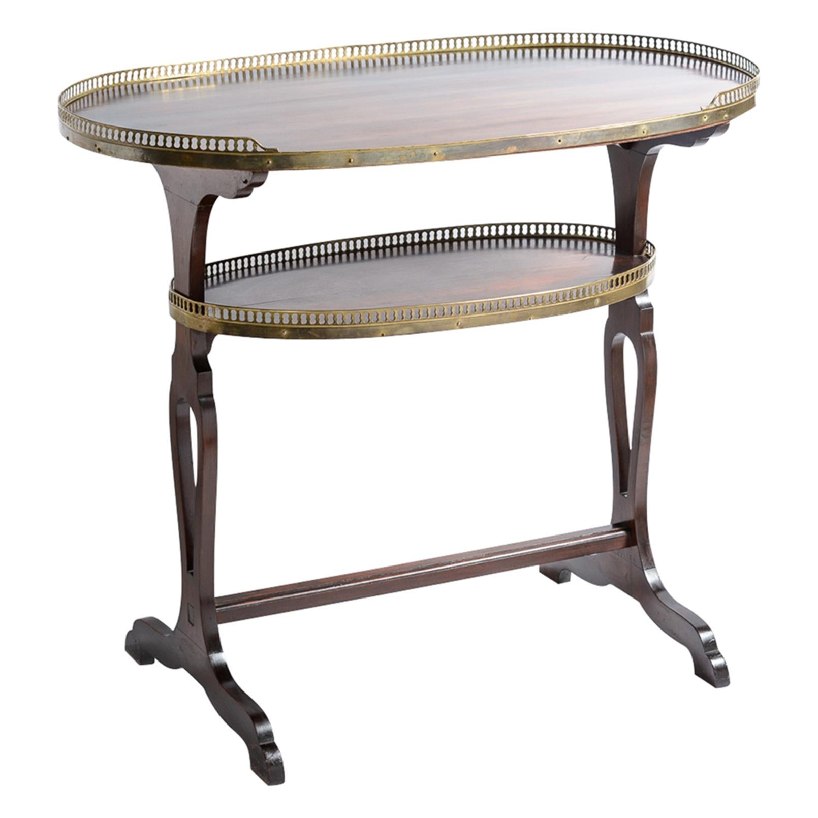 Un style Empire français d'une grande élégance   Table de maître en acajou en forme de rein avec galeries en laiton, 
Il y a deux étagères, l'une en haut et l'autre en bas, qui  ont la galerie réticulée de Brass
La forme du rein devait rapprocher le