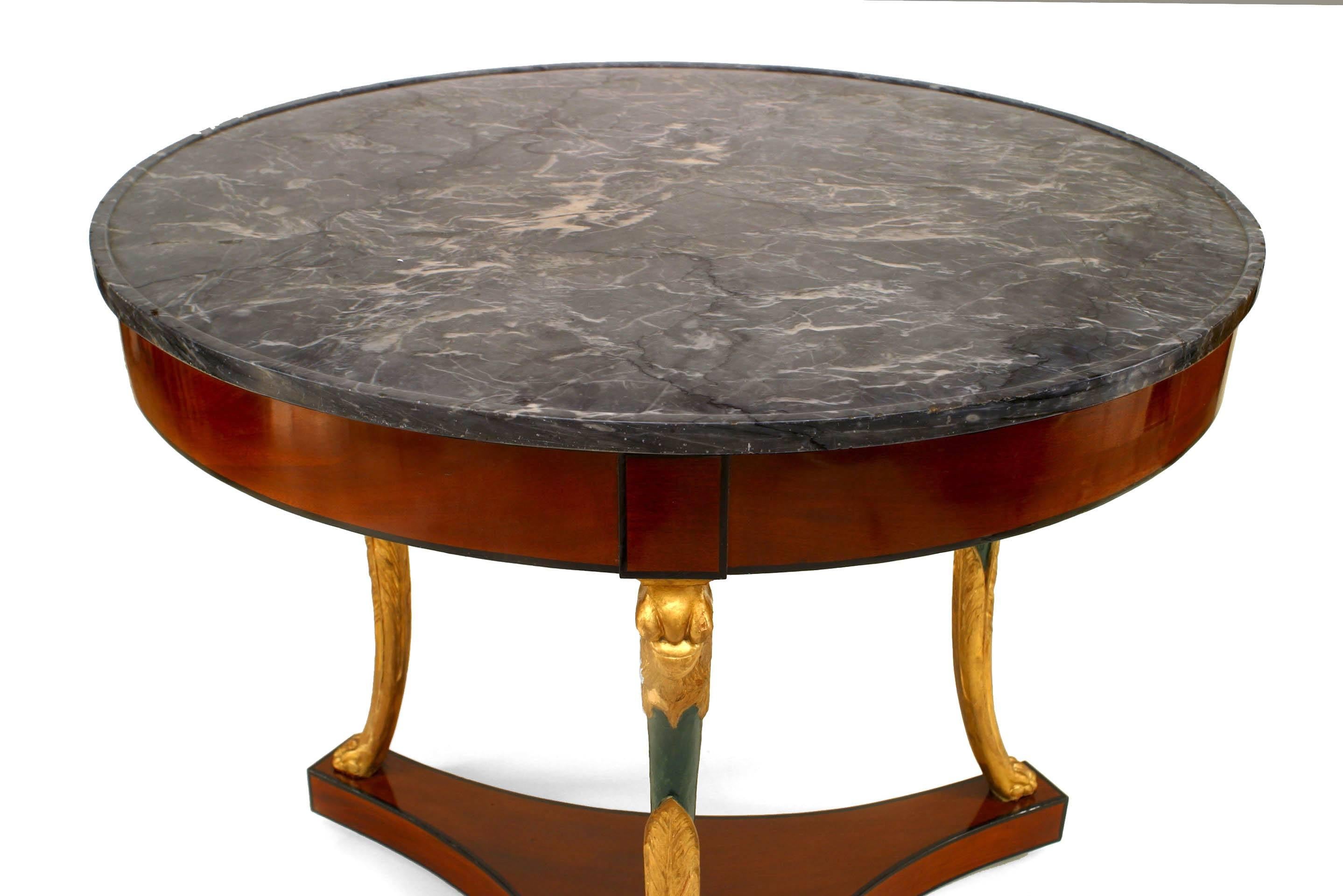 French Empire style (Circa 1825) mahogany and gilt round 3 legged center table on platform base with green lacquered bird heads and grey marble top.
