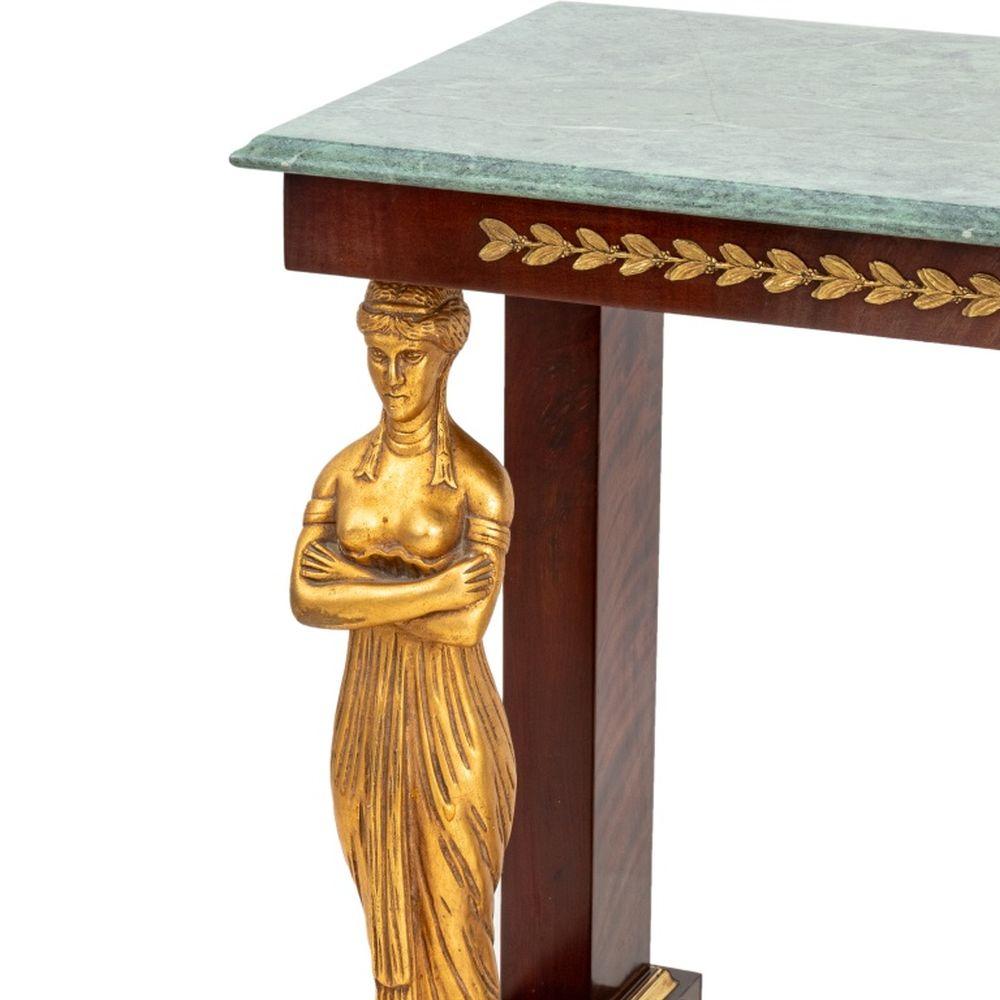 Console de style Empire en acajou, avec un plateau en marbre vert sur deux supports de vierge et des montures en laiton sur quatre pieds en chignon. 33
