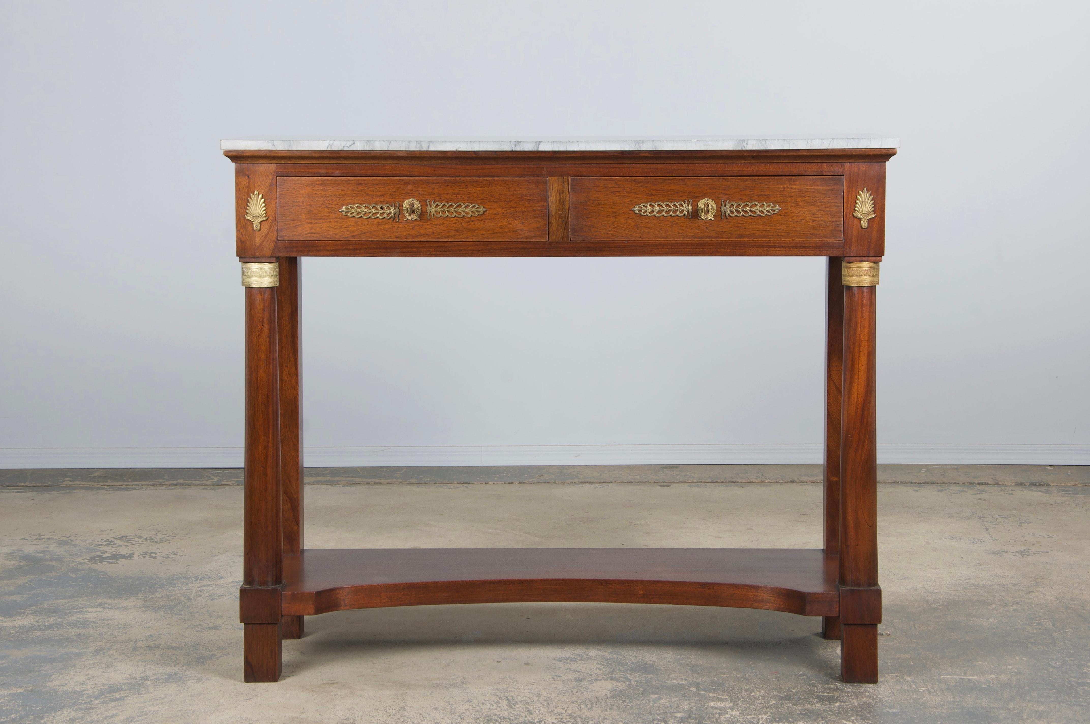 Handsome mid-20th-century French Empire-style console table, sourced from Provence. Expertly restored and refinished, this piece features a narrow mahogany frame with a richly aged surface, warm brown tones, and striking grain detail. It is paired