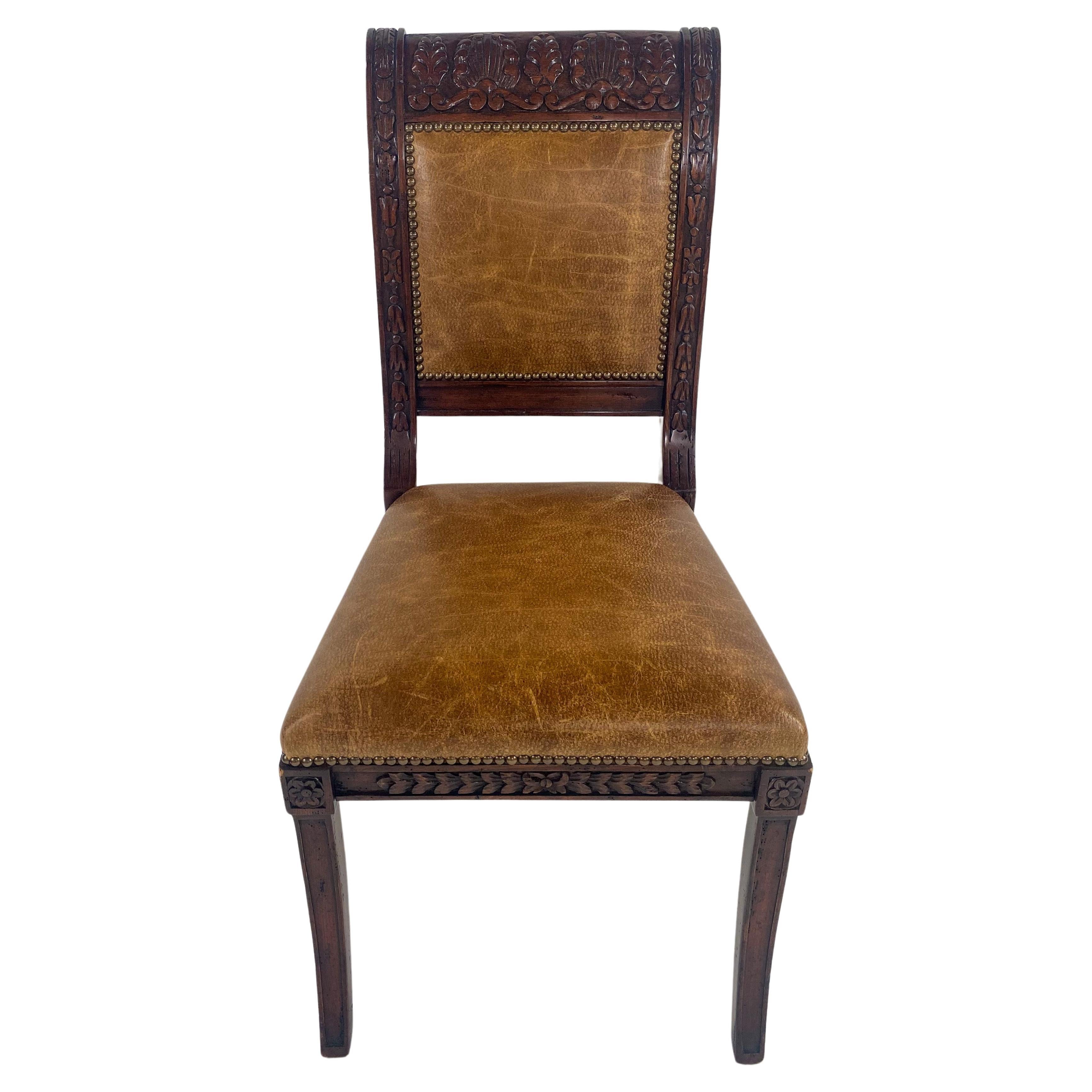 A stunning French Empire Style set of 8 dinning chairs. The chairs are made of quality Mahogany wood. The frame is exquisitely hand carved and shows amazing floral and acanthus patterns. The back and the seat are upholstered in genuine leather in