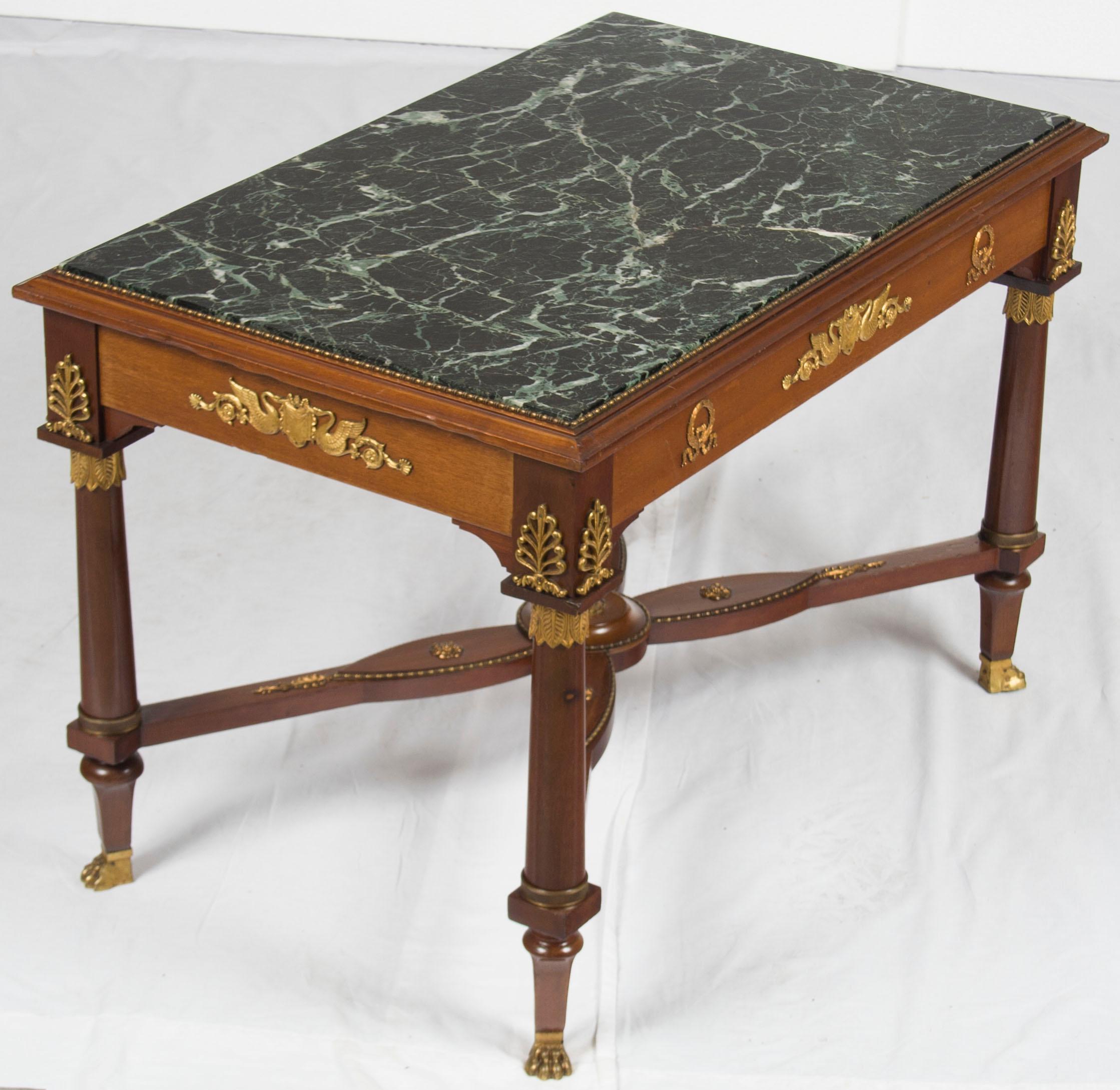 Done in a French Empire style, this antique marble top coffee table makes a central statement for your room! An inset highly figured green marble contrasts perfectly with the mahogany wood and brass accents. A great size for any home!

In keeping