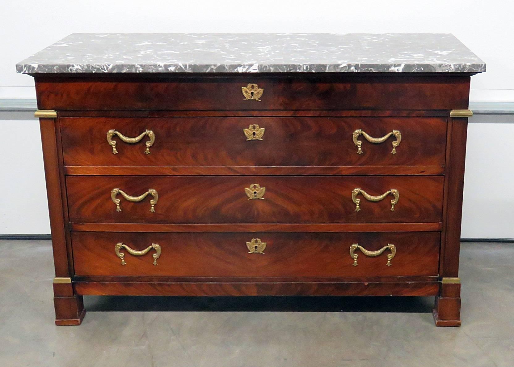 French Empire style marble-top four-drawer commode. Flame mahogany with brass accents.