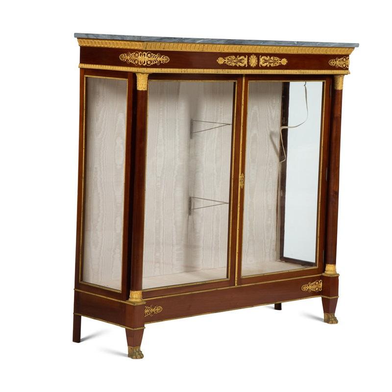a handsome pair of Empire-style gilt bronze mounted (ormolu) mahogany marble top vitrines / display cabinets, each with two interior glass shelves, glass on three (3) sides, back and bottom covered in ivory moire, France, 19th century, circa 1875
