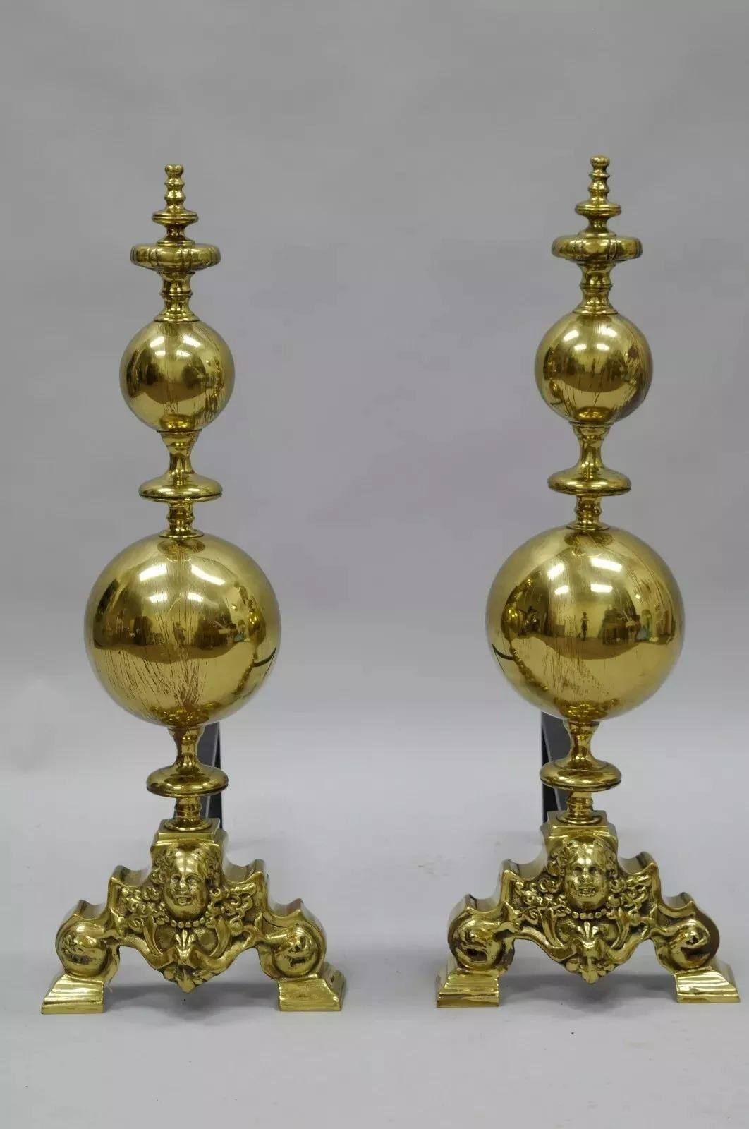 French Empire Style Putty Cherub Large Brass Cannonball Andirons - a Pair. Schwere Messingformen, große runde Kanonenkugeln, figurale Puttengesichter, gusseiserne Halterung, Messingknäufe. CIRCA Anfang des 20. Jahrhunderts. Abmessungen: 30,5