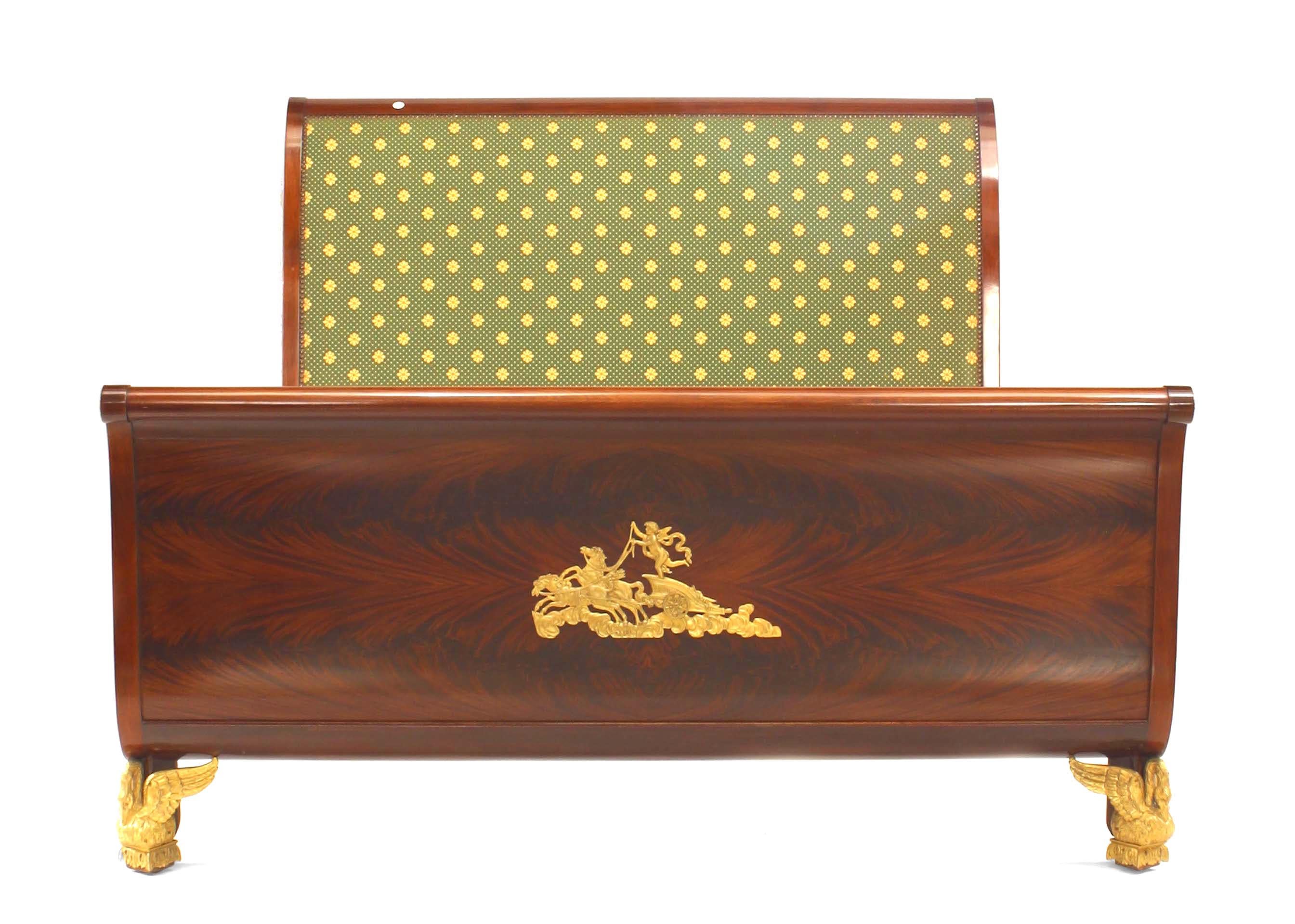 French Empire-style (19/20th Century) mahogany queen size bed with gilt bronze trim and upholstered panel on headboard (includes: headboard, footboard, rails).
