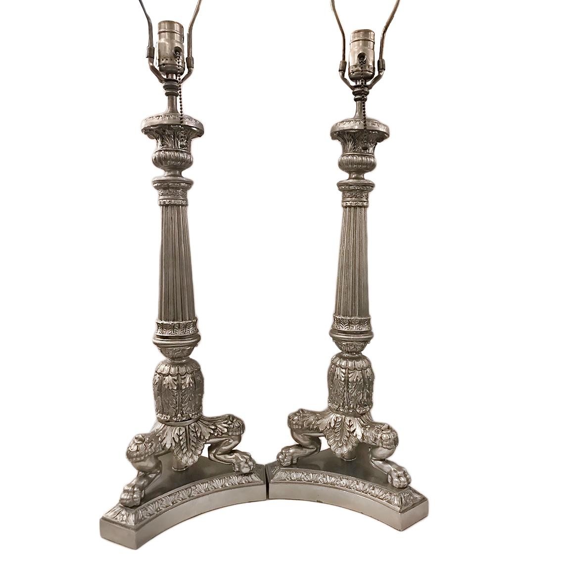 A pair of circa 1930s French nickel-plated three-footed candlesticks wired as lamps with intricate detailing in the Empire style.

Measurements:
Height of body: 20