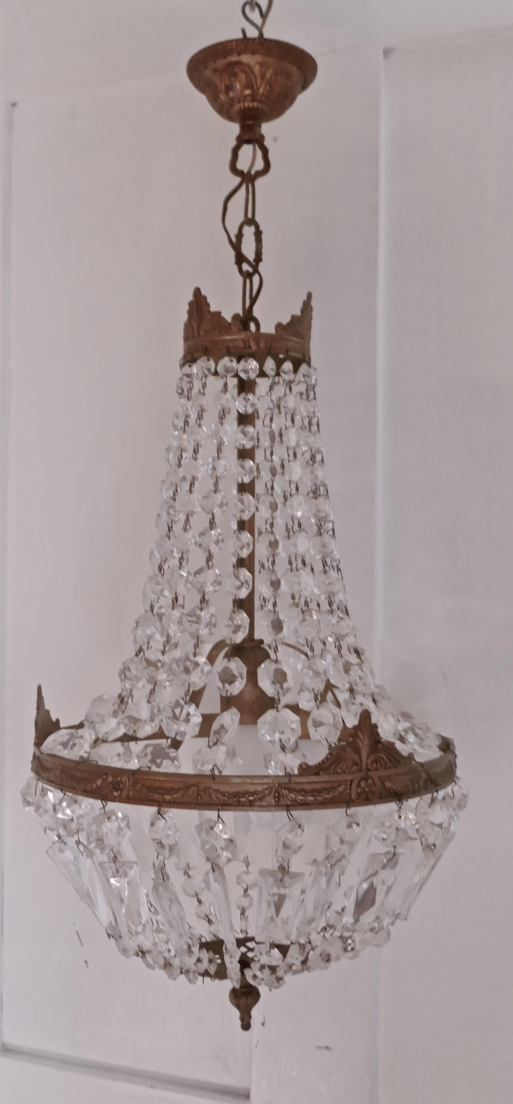 French Empire style tent chandelier

This is a lovely piece especially where a very large chandelier is not possible, it has an aged brass frame hung with chains of cut glass beads, completed at the bottom with a basket of cut glass drops

The