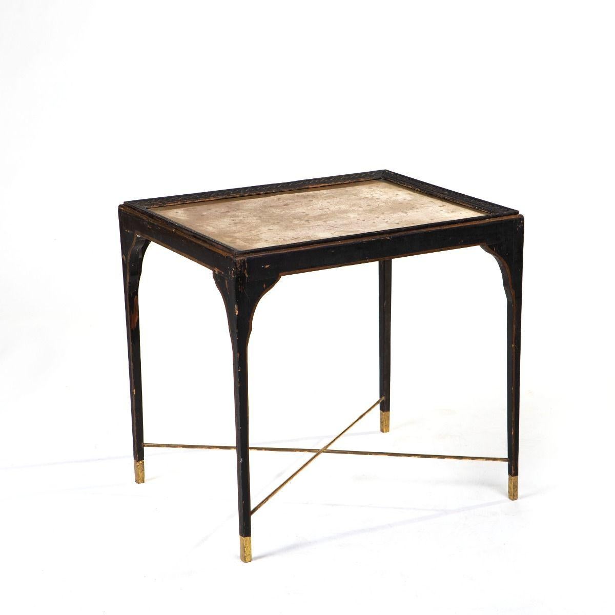 Elegante tavolino impero francese del 1810 circa, in legno dipinto di nero con un vassoio rimovibile incastonato da una piastra in ottone e incorniciato da dettagli finemente intagliati. Il tavolo è conservato nelle sue condizioni originali e