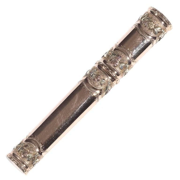 
French tri-colored, red, green and yellow 18Kt gold pencil case decorated with applied classical lobes, swags and festoons of flowers. 
French rubbed mark, circa 1810
Width: 12 mm
Height: 90 mm 
Weight: 15.7 gr.