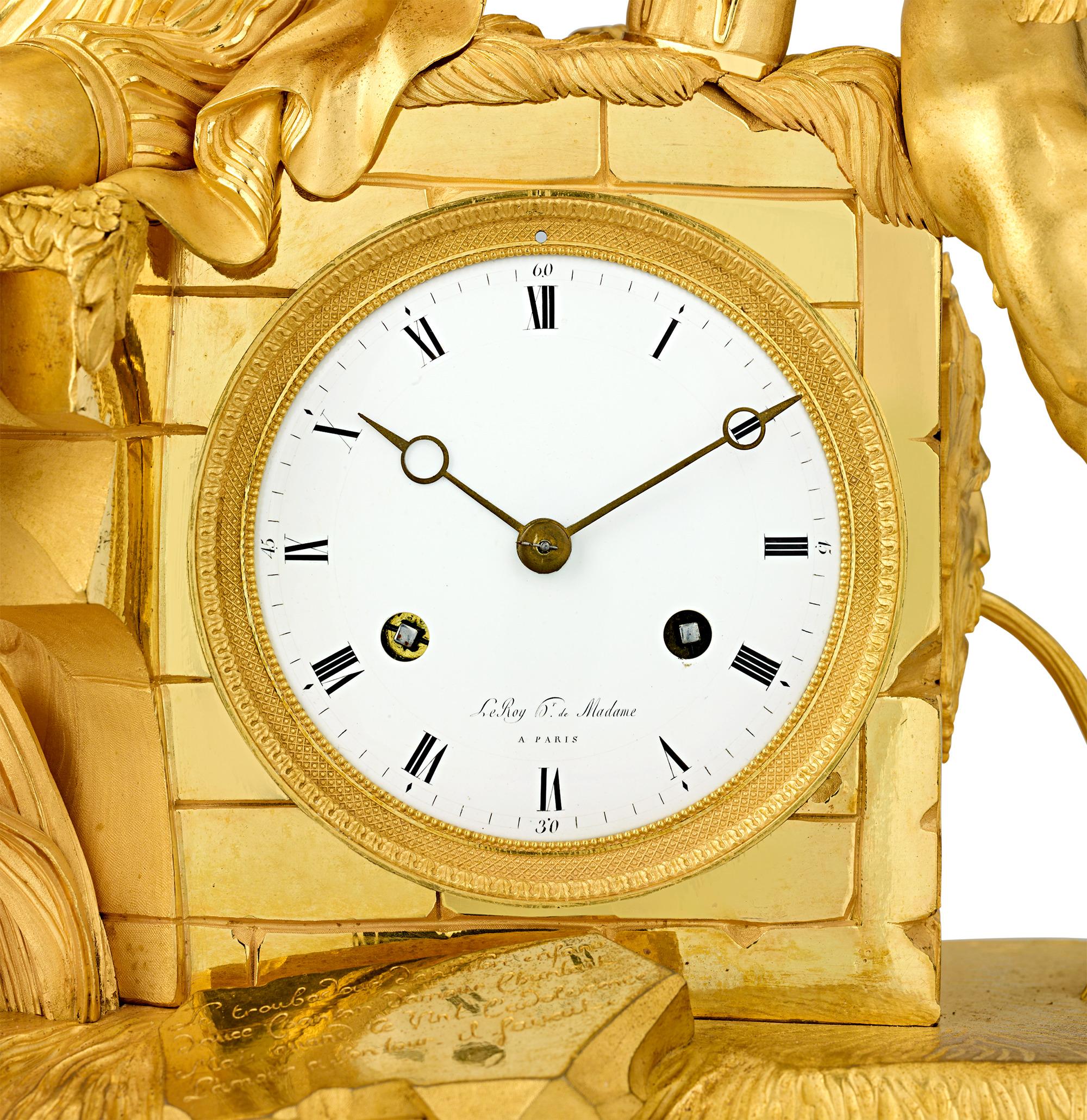 This resplendent French Empire gilt bronze mantel clock features an extraordinarily detailed scene of a singing troubadour with his lyre along a rocky river bank. Accompanied by a winged Cupid suspended gracefully in flight and a poetic inscription,