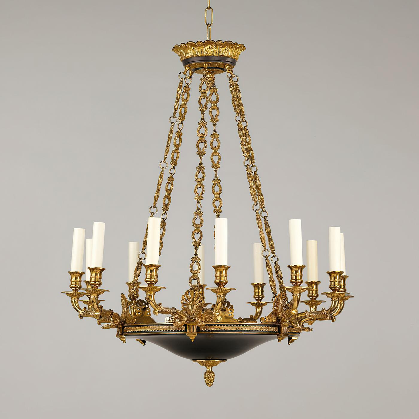 French Empire twelve-light chandelier, the ornate decoration on the arms, and the arrangement of the chains demonstrate exceptional casting in brass. With beautifully cast floral details of acanthus and palmettes, with acorn finials and a black