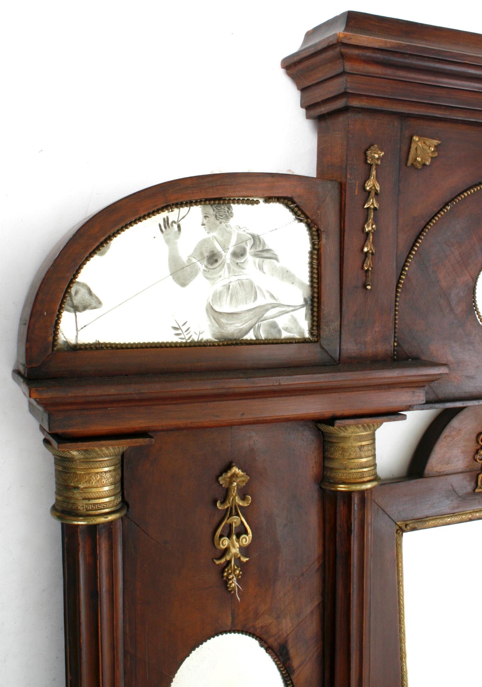 French Empire vanity mirror with original reverse etched glass panels, circa 1800, of classical figures. It has original gilded classical mounts. There are three small drawers and a central tilting mirror.
  