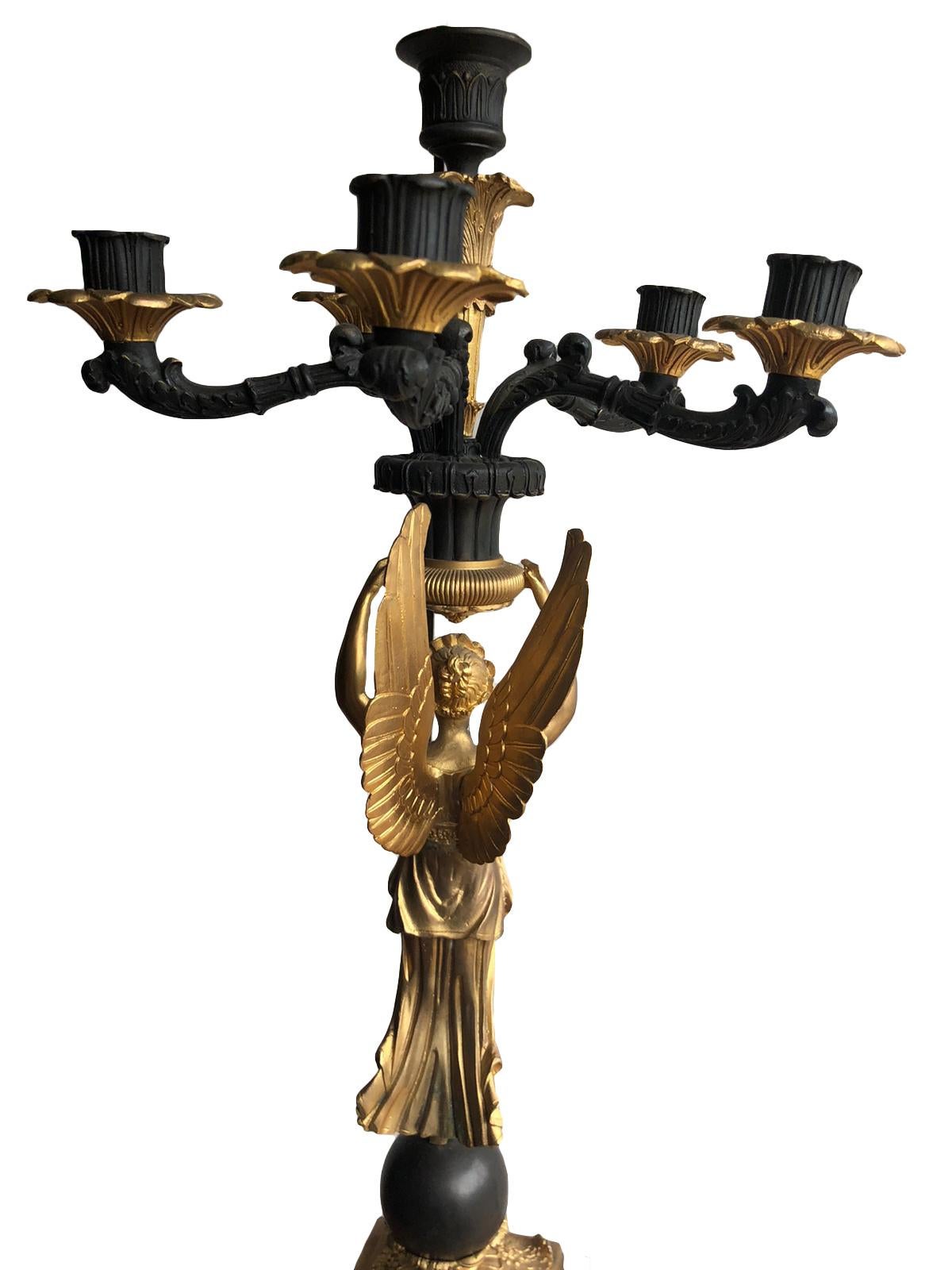 Pair of French Empires style gilt bronze angel candelabras. The quality is superb, very intricate and detailed with black and gilt bronze.

Size: Height 28 inches
Diameter 10 inches.