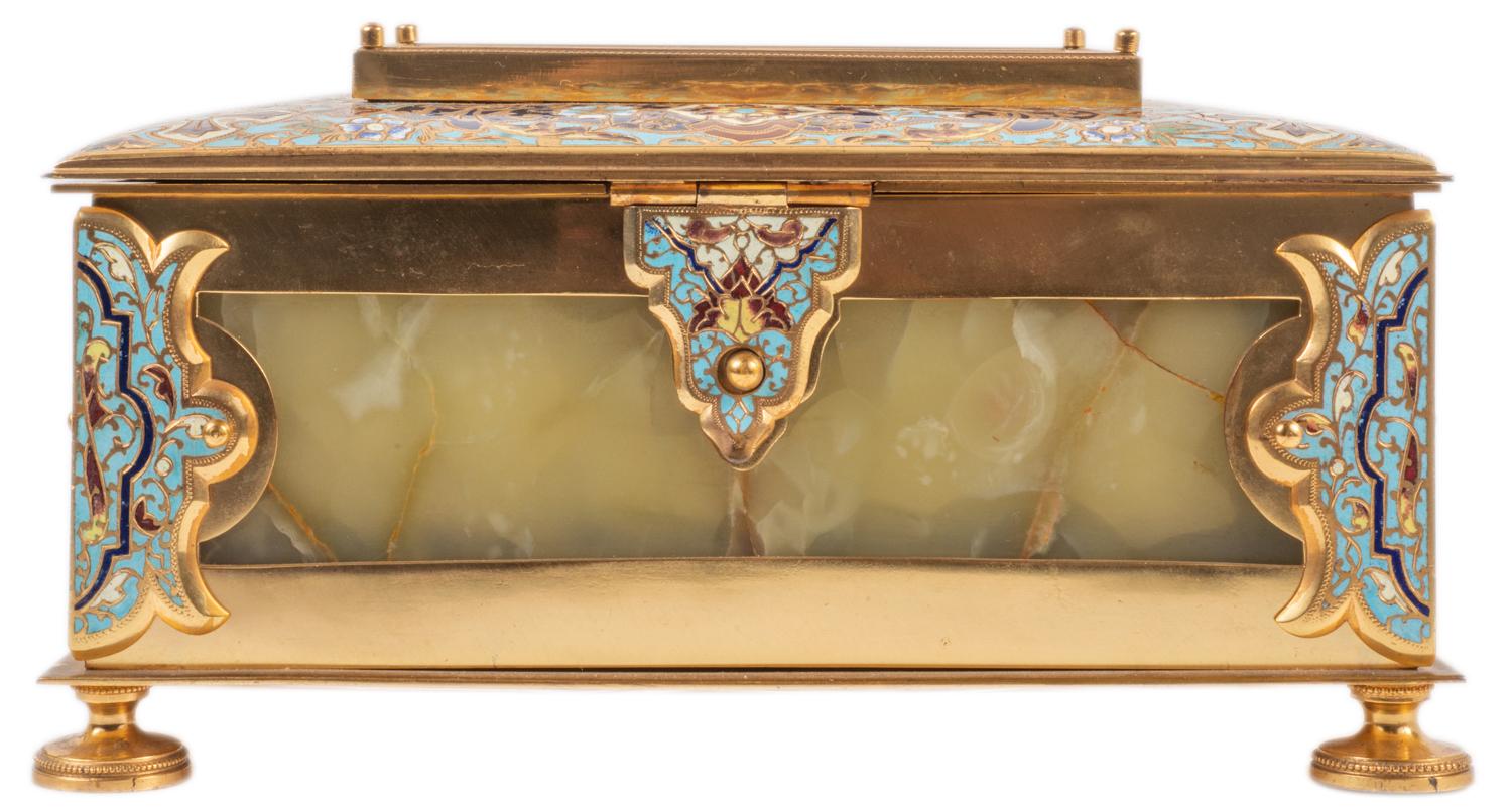 A very good quality late 19th century French gilded ormolu, champlevé enamel and porcelain casket. The hinged top with enamel boarder and an inset porcelain plaque depicting lovers, opening to reveal a velvet lined interior. The box having onyx
