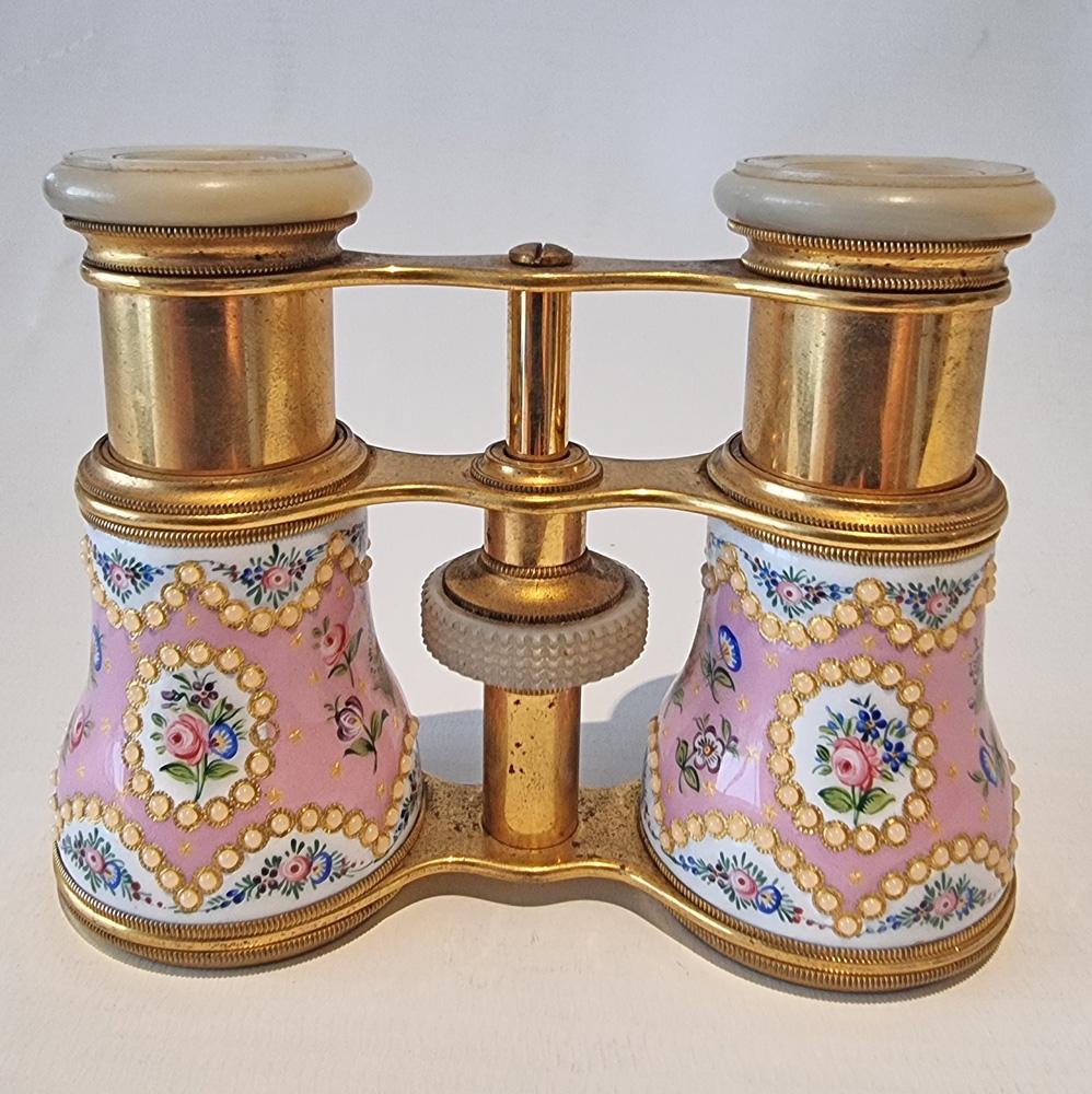 A fine pair of French enamel, brass and mother of pearl opera glasses, pink enamelled and jewelled barrels, with mother of pearl caps. Good condition, the pink enamel with hand painted flowers. Invented in the 19th century, this must-have accessory
