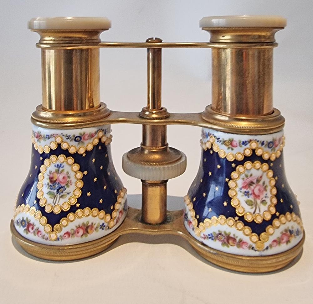A fine pair of French enamel, brass and mother of pearl opera glasses, Royal blue enamelled and jewelled barrels, with mother of pearl caps,  inscribed 'J S Marratt 63 King Willm St Optician London Bridge'. Invented in the 19th century, this