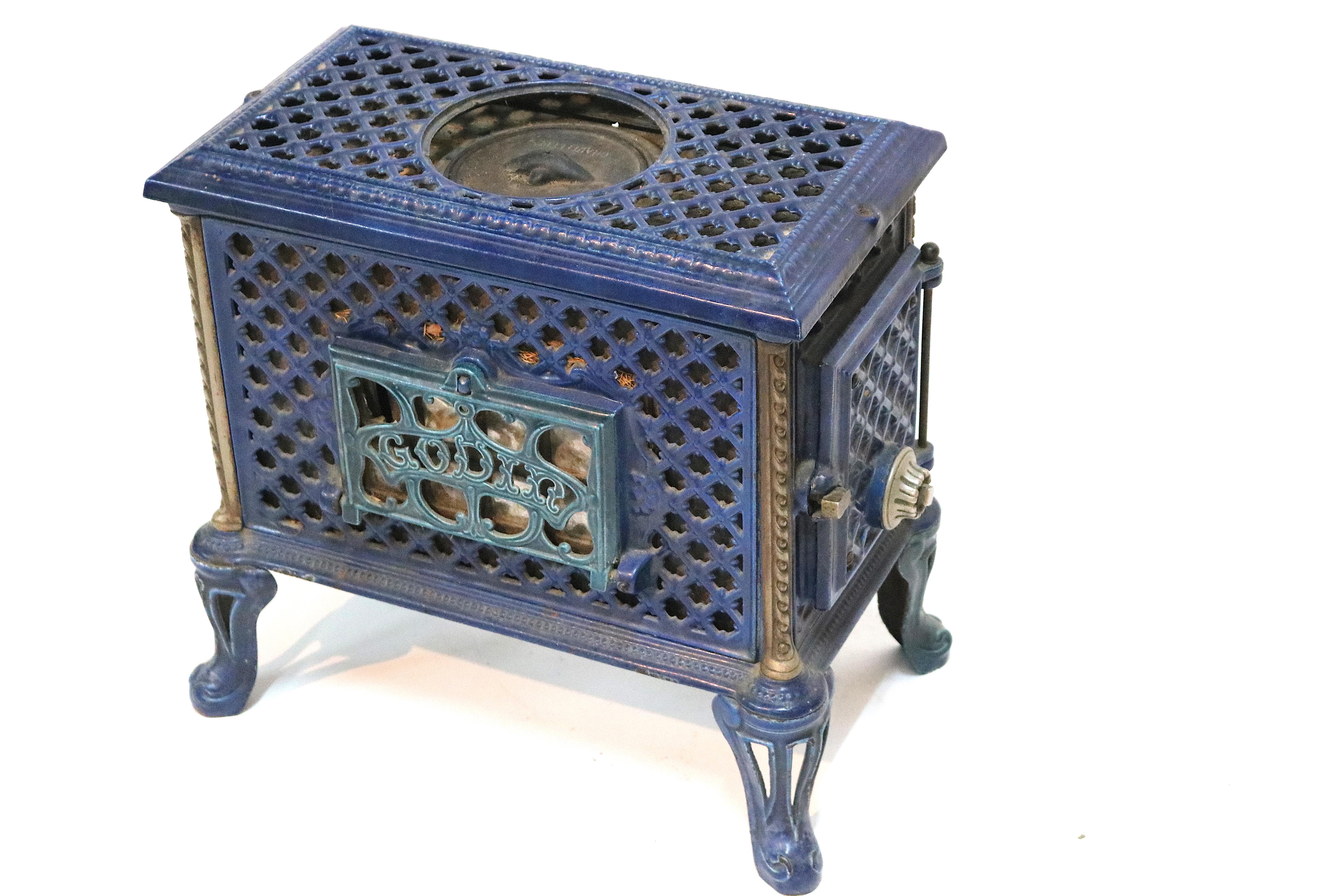 Dieser charmante Kaminofen ist eine einzigartige Ergänzung für jedes eklektische Ambiente mit einer satten, blau glänzenden Emailleoberfläche und einer vielseitigen Verwendung. Chauffette mit Gravur in der Deckelkappe mit Grippöffnung. Filigrane