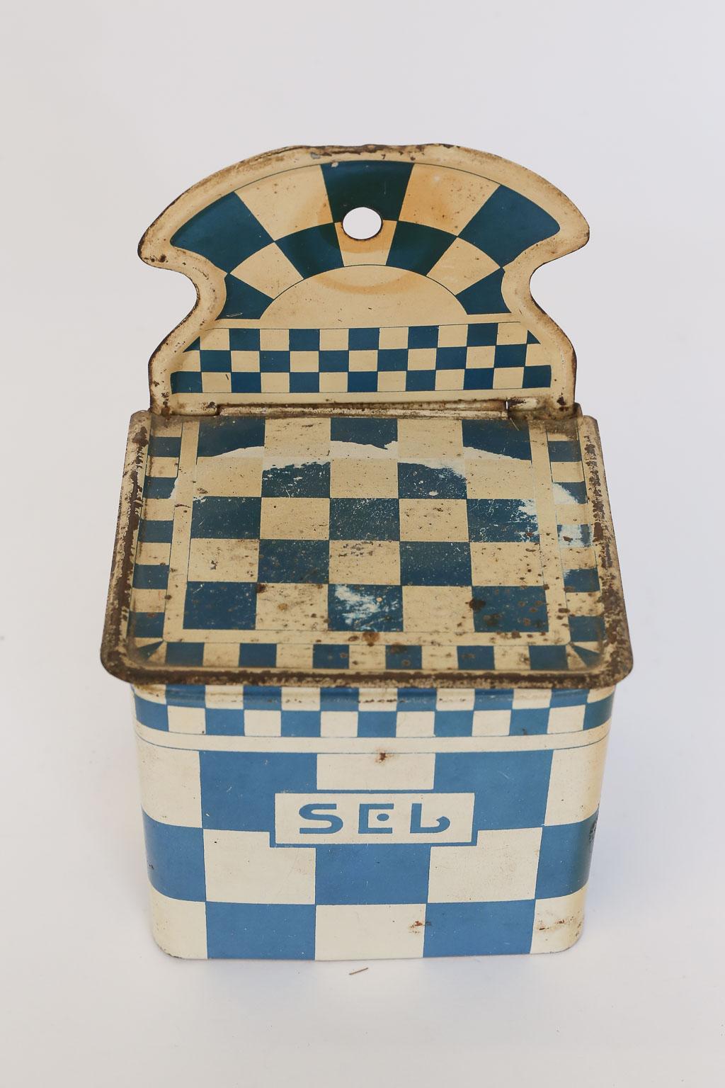 This is an antique French enamel salt cellar with a lovely blue and white checkerboard pattern. The box was designed to be hung on the wall or rest beautifully on your counter or tabletop. Lined with wood, your salt will be kept clean and dry.