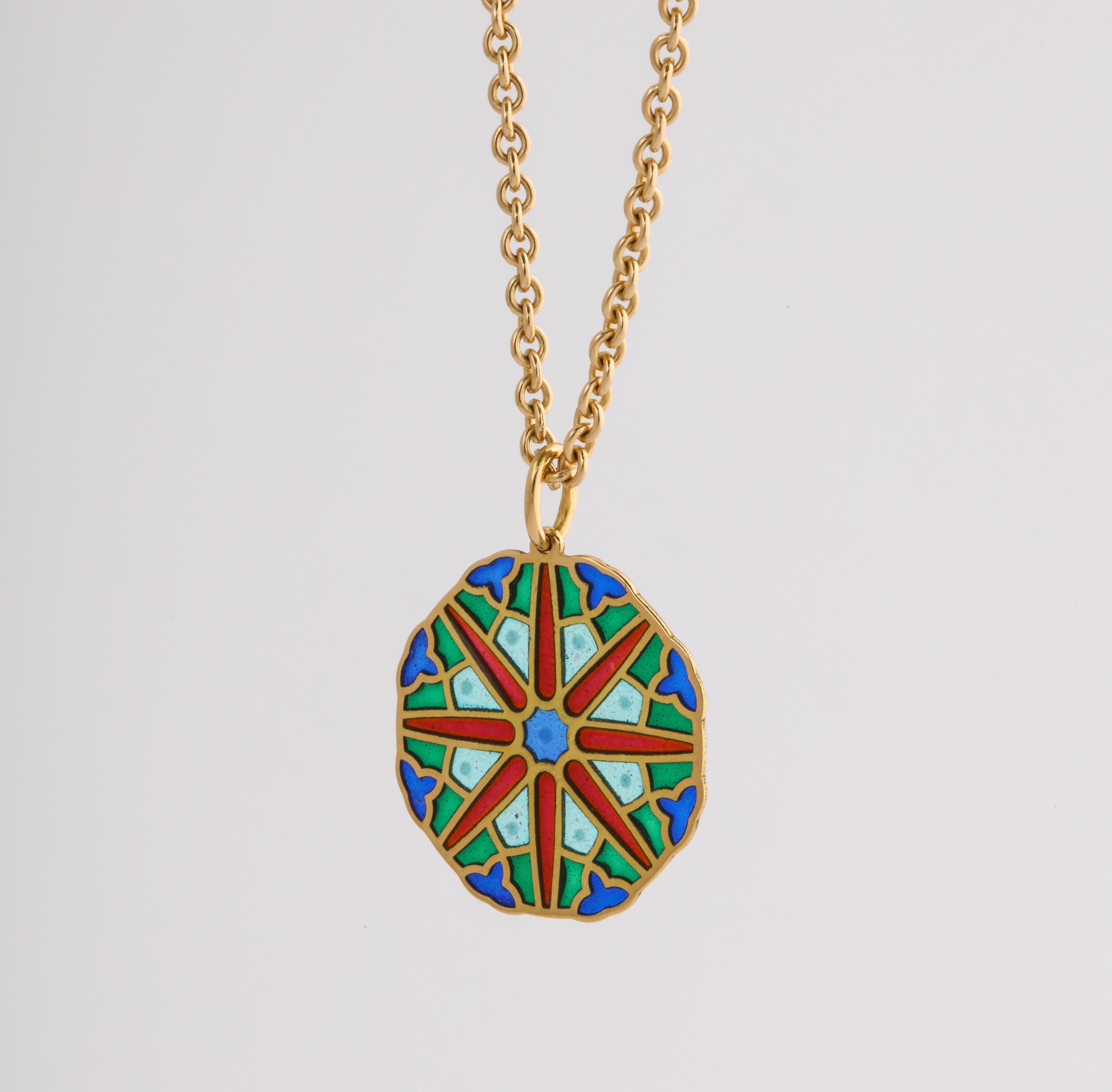 Recalling the Gothic stain glass windows of the French Cathedral in the city of Orléans, this 18k gold pendant is decorated with vibrant plique-a-jour (transparent) enamel colors, separated by gold cloisons, a unique pendant designed and created