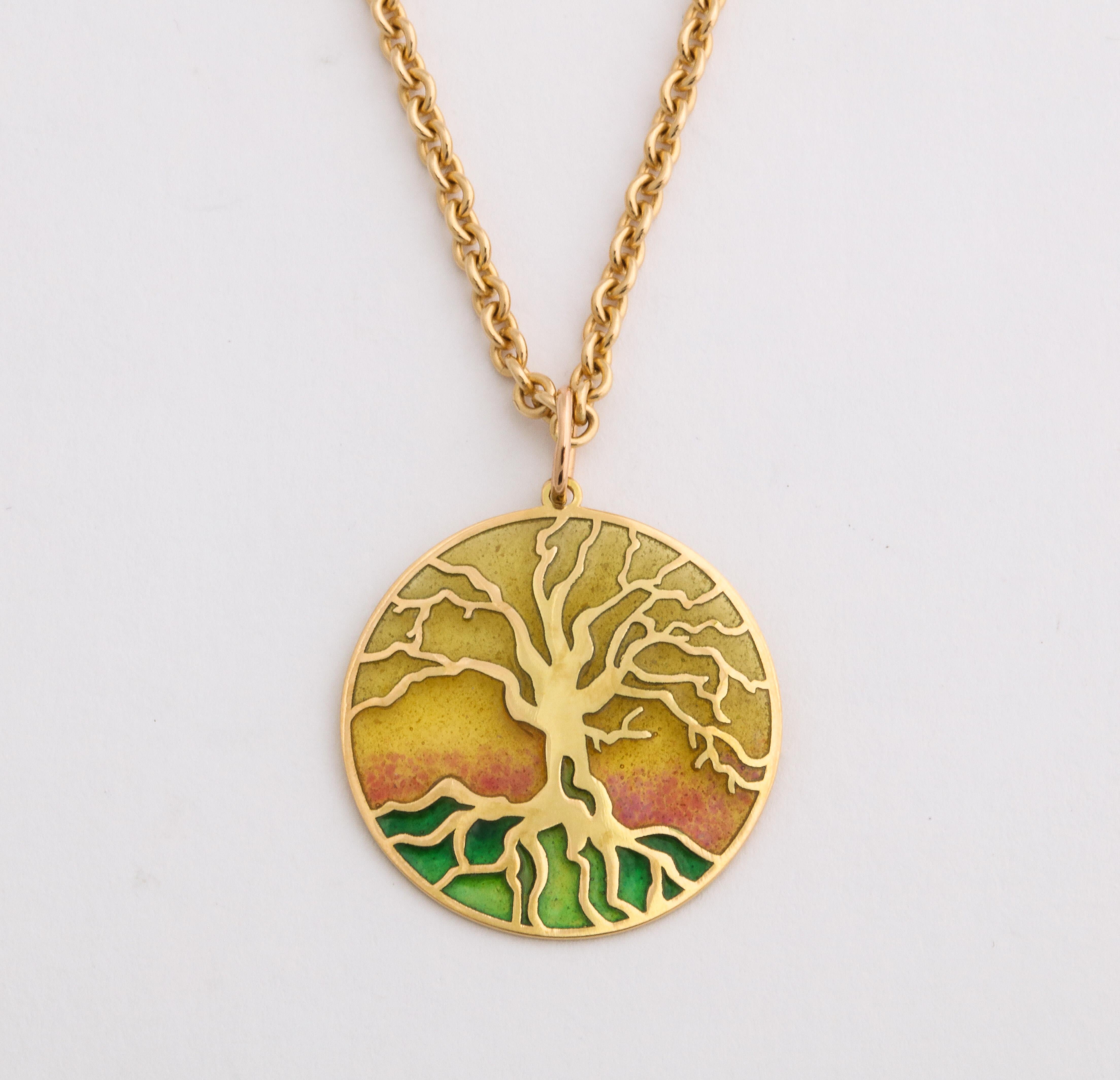 Designed as an arbre de vie or tree of life, a symbol of immortality, this 18k gold pendant is decorated with plique-a-jour (transparent) enamel in shades of rose, pale yellow and verdant green, separated by gold cloisons, the gnarled tree and