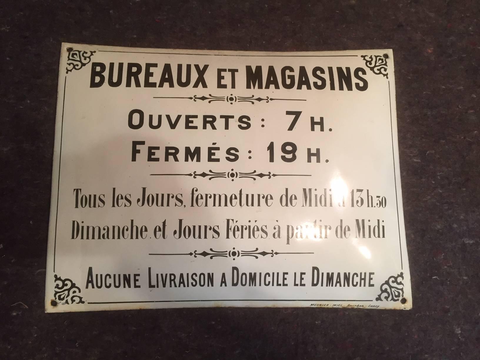French curved enamelled sheet metal advertising sign.
English translate:
Office and stores
Open: 7 am
Closed: 19 pm
Every day close from Midday to 13.30 pm
Sunday and Public holiday from noon
No home delivery on Sunday’s.