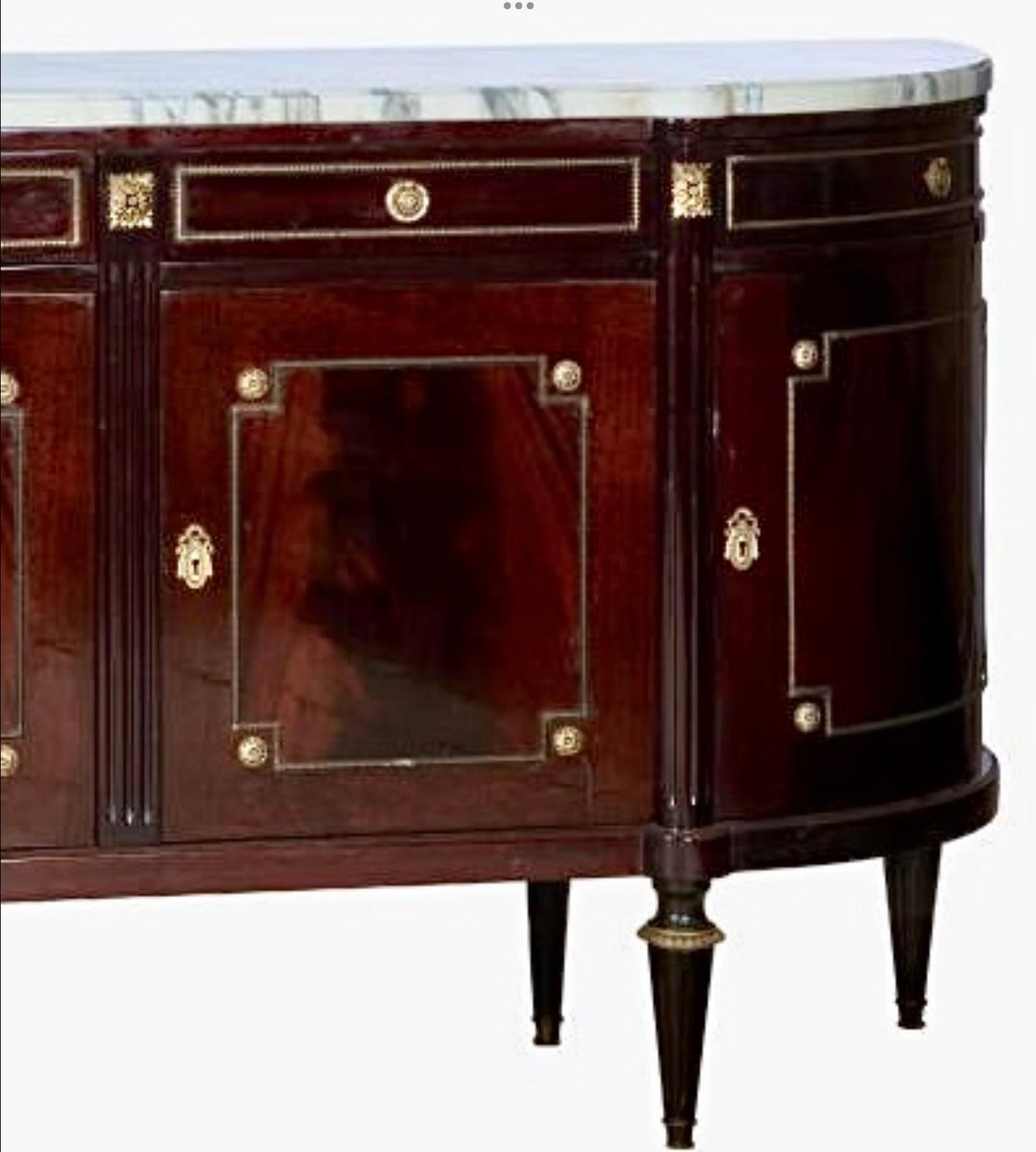 Exceptional early 20th Century French Louis XVI Style Marble Top Enfilade/ Sideboard. Enfilade features molded marble top and turret front. There are five frieze drawers over five doors, providing storage while maintaining the clean lines and