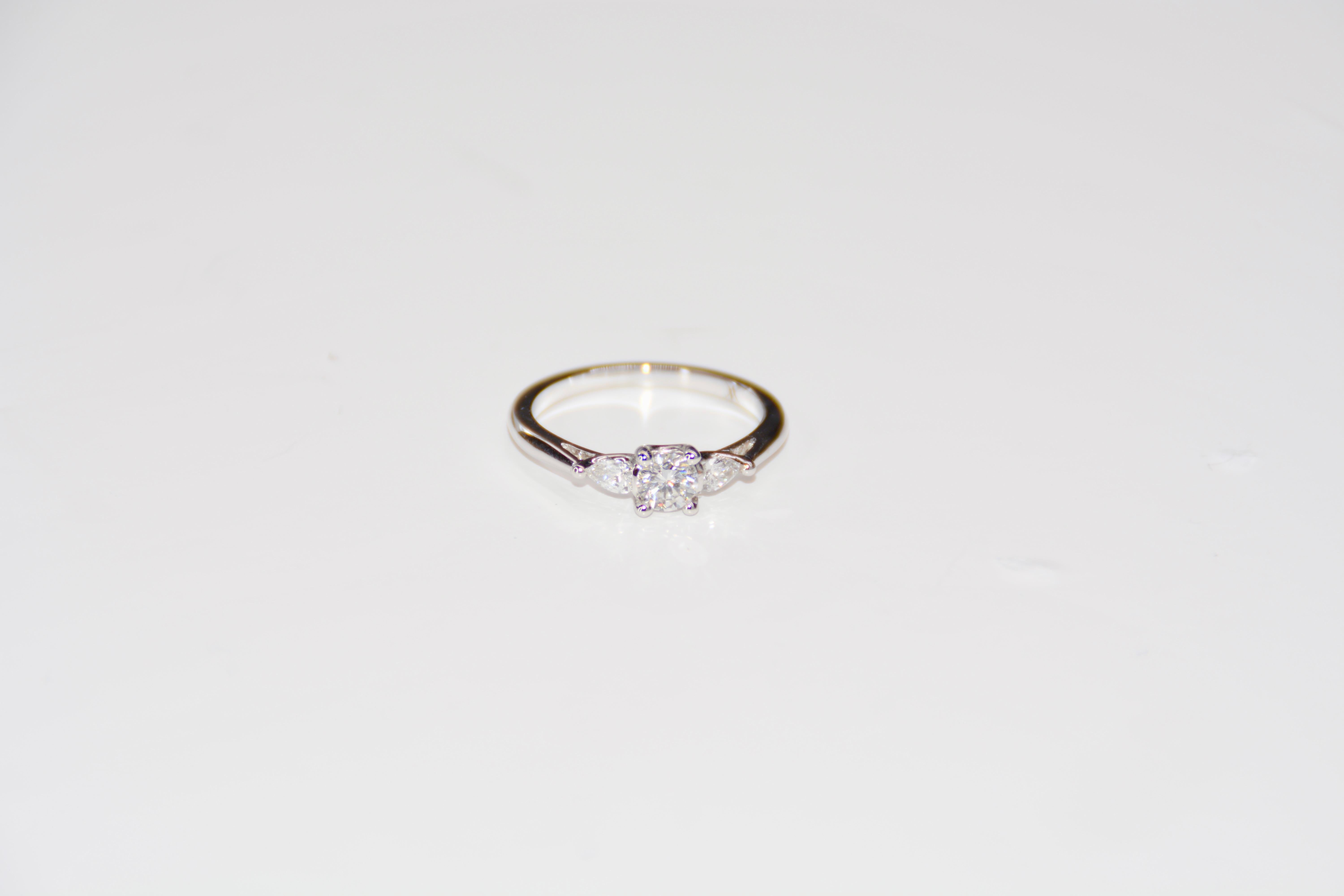 French Engagement Ring White Gold Set with Diamonds

Beautiful solitaire ring in white gold set with 3 diamonds. 1 central brilliant-cut diamond, weighing 0.310 carats, color E, purity VS2. This diamond is surrounded by a pear-shaped diamond of