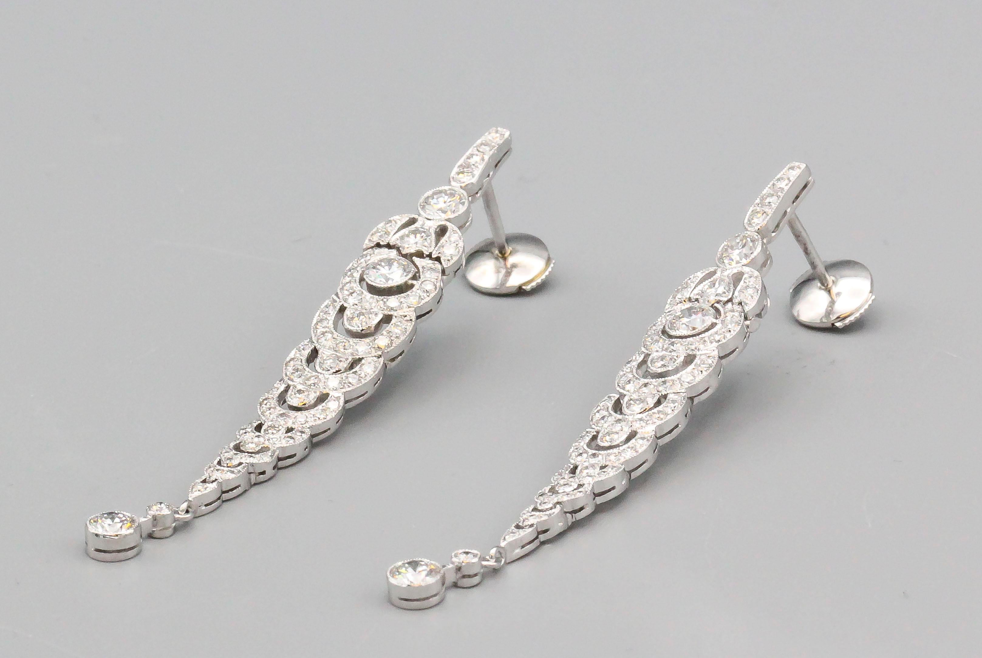 Fine pair of estate diamond and platinum drop earrings of French origin.  They feature high grade round brilliant cut diamonds of approx. 3-4 carats total weight. 

Hallmarks: French 18k gold assay marks